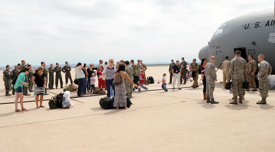 Dyess Airmen and family members gather on the flightline to greet returning friends and family Sept. 11, 2014, at Dyess Air Force Base, Texas. Airmen from the 39th and 40th Airlift Squadrons and the 317th Aircraft Maintenance Squadron were deployed in support of Operation Enduring Freedom and Horn of Africa operations, where they provided military and forward operating base buildup and completed humanitarian aid missions. (U.S. Air Force photo by Senior Airman Shannon Hall/Released)