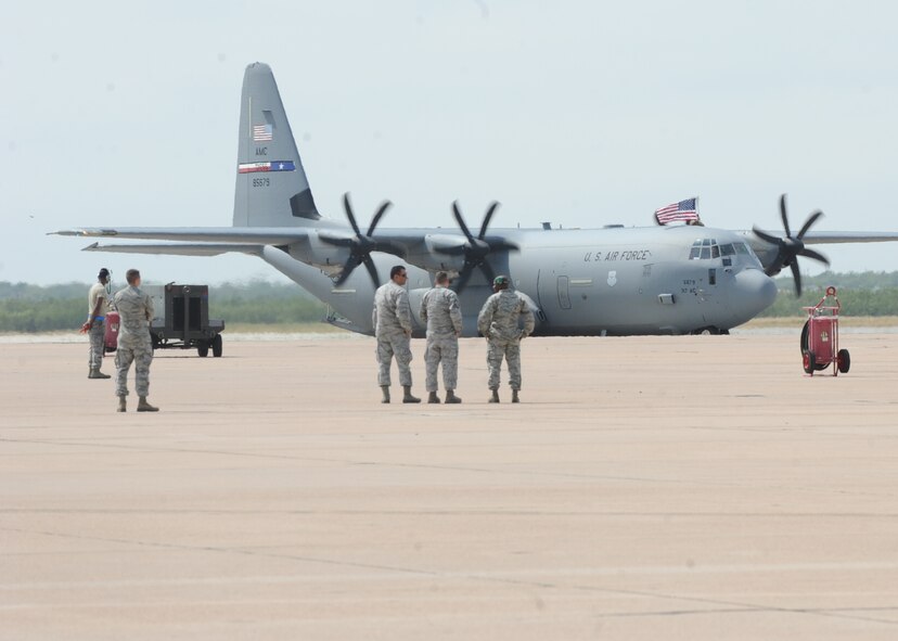 An Airman waves a flag out of the top hatch of a U.S. Air Force C130J Super Hercules as it taxis on the runway Sept. 11, 2014, at Dyess Air Force Base, Texas. Airmen from the 39th and 40th Airlift Squadrons and the 317th Aircraft Maintenance Squadron were deployed in support of Operation Enduring Freedom and Horn of Africa operations. (U.S. Air Force photo by Senior Airman Shannon Hall/Released)
