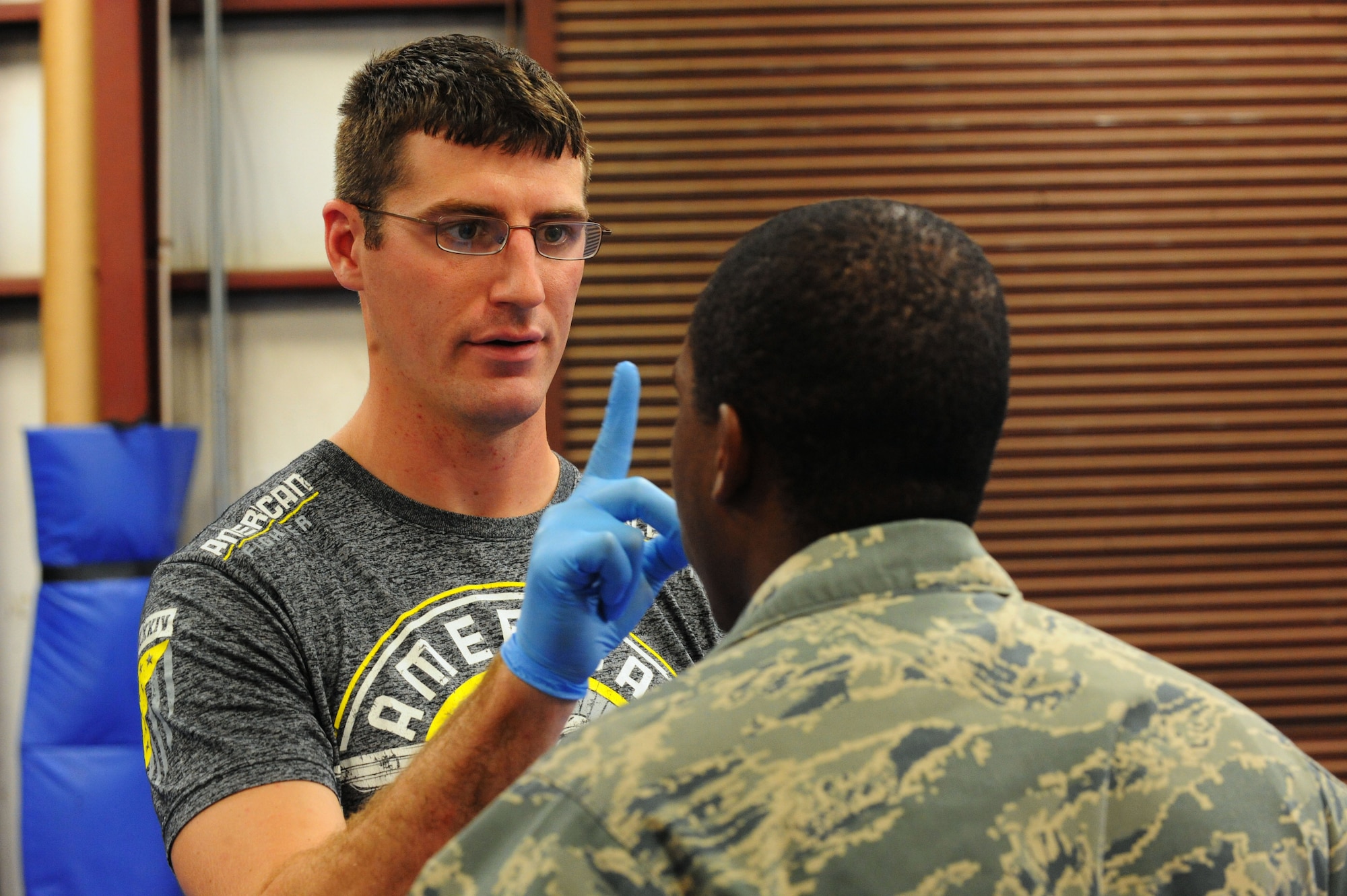 U.S. Army Sgt. Justin Karlewicz, U.S. Army Central medic, assesses U.S. Air Force Staff Sgt. Edward Leslie, 20th Security Forces Squadron standards and evaluation technician, after a sparring match with a Modern Army Combative Program instructor at Shaw Air Force Base, S.C., Sept. 10, 2014. Students are monitored closely throughout their training to ensure no injuries are sustained. (U.S. Air Force photo by Airman 1st Class Michael Cossaboom/Released)