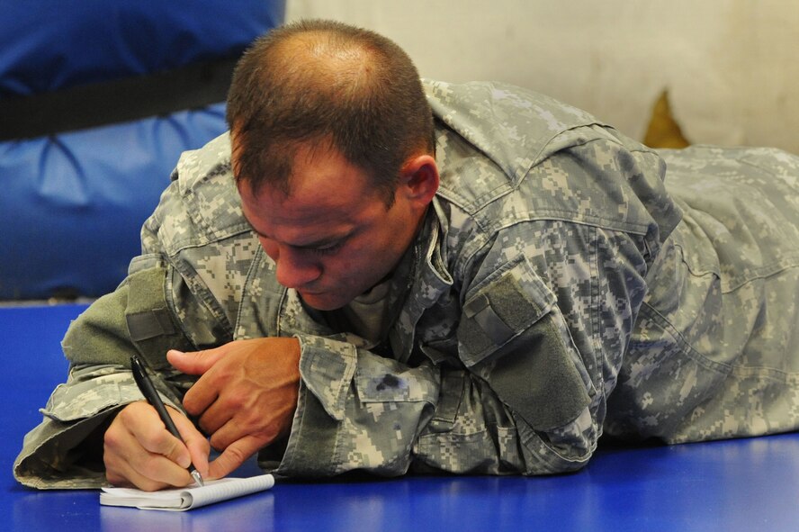 U.S. Army Maj. David Glad, U.S. Army Central medical logistics planner, writes in his notebook during a Modern Army Combative Program class at Shaw Air Force Base, S.C., Sept. 9, 2014. Throughout the class, Airmen and soldiers learned basic, close-quarters, hand-to-hand combat skills. (U.S. Air Force photo by Airman 1st Class Michael Cossaboom/Released)