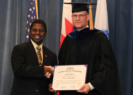 Dr. Adedeji Badiru, dean, AFIT School of Engineering and Management, (left) congratulates Master Sgt. Jeffery Morris on the granting of his doctor of philosophy. (Contributed photo)