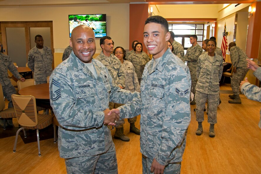 Nineteen-year-old Airman 1st Class Jordan Pare, a member of the 70th Aerial Port Squadron and Homestead Air Reserve Base’s youngest available Airman shakes hands with Chief Master Sgt. Katdo Robinson, 482nd Fighter Wing interim command chief, after cutting the first slice of cake at the Community Activity Center at Homestead ARB, Fla., 7 Sept.  In order to continue a strong Heritage and to celebrate the Air Force's 67th birthday, which is 18 Sept., the Wing tracked down the youngest available Airman currently on Homestead ARB to cut and receive the first slice of birthday cake.  (U.S. Air Force photo by Senior Airman Nicholas Caceres)