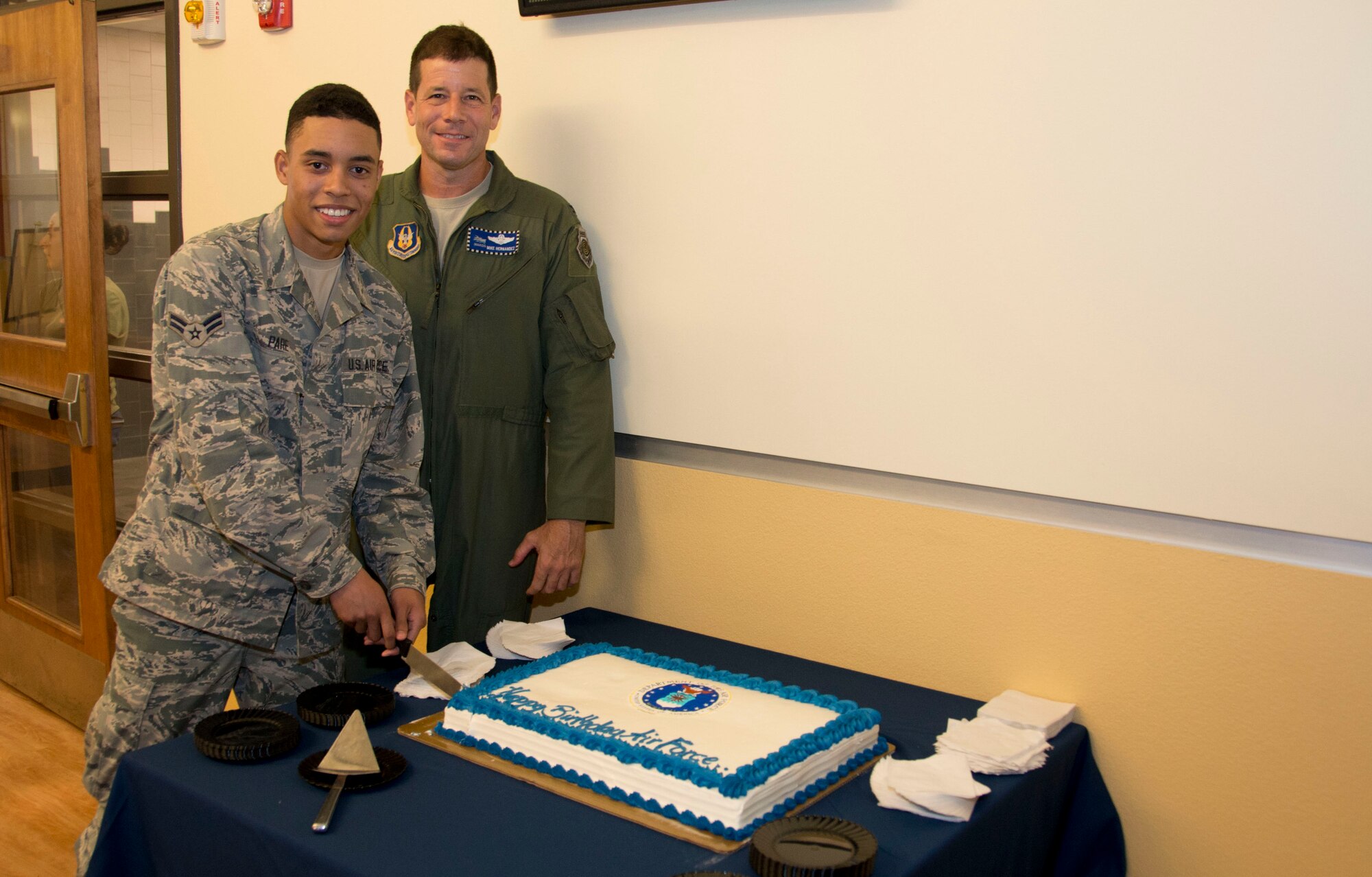 Nineteen-year-old Airman 1st Class Jordan Pare, a member of the 70th Aerial Port Squadron and Homestead Air Reserve Base’s youngest available Airman and Col. Michael Hernandez, 482nd Fighter Wing vice commander, pose for a photo while Pare cuts the first slice of cake at the Community Activity Center at Homestead ARB, Fla., 7 Sept.  In order to continue a strong Heritage and to celebrate the Air Force's 67th birthday, which is 18 Sept., the Wing tracked down the youngest available Airman currently on Homestead ARB to cut and receive the first slice of birthday cake. (U.S. Air Force photo by Senior Airman Nicholas Caceres)