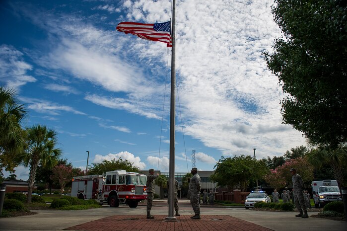 Airmen prepare to lower the colors during a 9/11 memorial ceremony Sep. 11, 2014, at Joint Base Charleston, S.C. The flag was flown at half staff through out the nation in memory of the victims of 9/11. The retreat ceremony was a poignant reminder of the events of 13 years ago, and the continuing efforts today’s military is making against the War on Terrorism. (U.S. Air Force photo/Airman 1st Class Clayton Cupit)