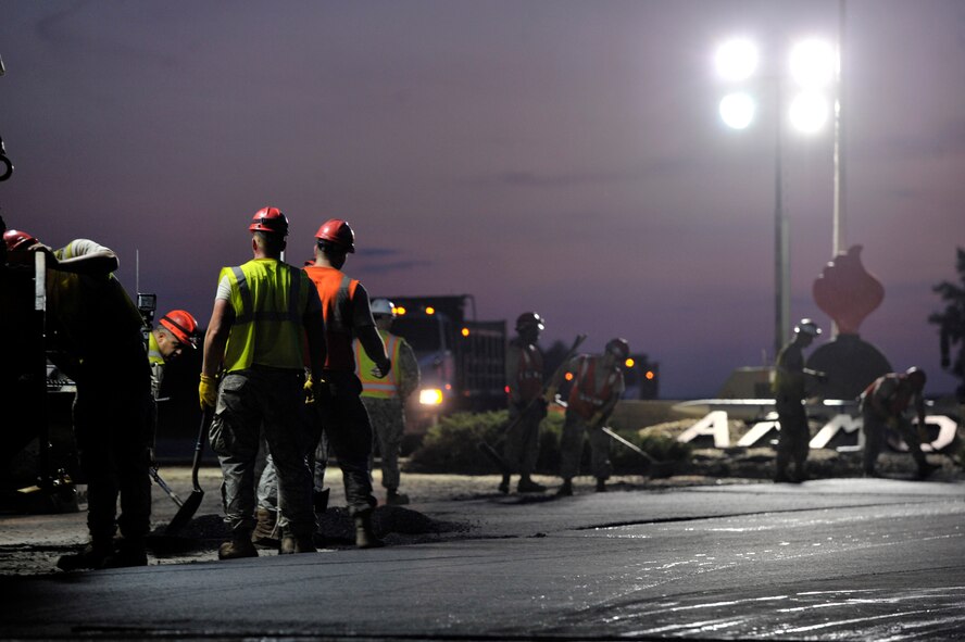 U.S. Air Force and U.S. Navy personnel assigned to the 823rd Rapid Engineer Deployable Heavy Operational Repair Squadron Engineers assigned to Hurlburt Field, Fla., repave the entrance of the 20th Equipment Maintenance Squadron munitions flight compound at Shaw Air Force Base, S.C., Sept. 10, 2014. The crew worked 12-hour shifts to lay down new road at the compound. The 823rd RED HORSE has been repaving roads at Shaw since March. (U.S. Air Force photo by Airman 1st Class Jonathan Bass/Released)