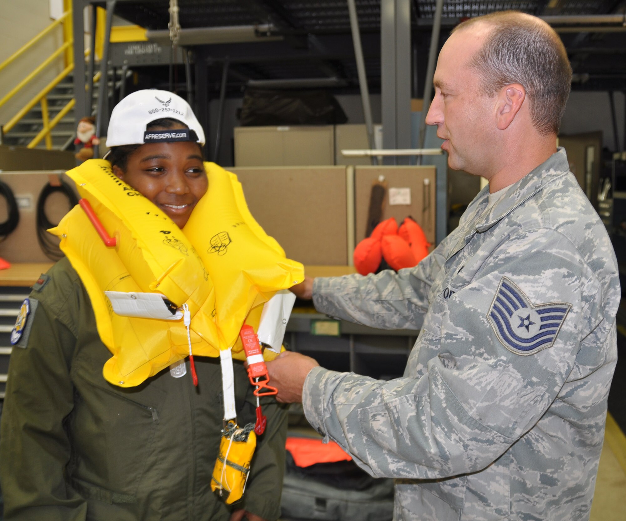 U.S. Air Force Reserve Technical Sgt. Charles Runnion, an Aircrew Flight Equipment Craftsman with the 910th Operations Support Squadron, explains how to inflate a flotation device to Pilot for a Day and honorary 2nd Lieutenant Javionte Allen here, Sept. 10, 2014. Javionte came to the Youngstown Air Reserve Station where he was sworn in as the 59th Pilot for a Day and an honorary 2nd Lieutenant. His day included a base tour, high-speed taxi down the flight strip in a C-130H Hercules aircraft, a tour of the base fire department that included the chance to control a crash response truck water cannon and a Marine Corps Humvee shuttle, provided by the Marine Corps Reserve center here. The 910th Airlift Wing pilot for a day program began in 2000 to give children a break from being treated for chronic or life threatening conditions. U.S. Air Force photo by Maj. Brent J. Davis