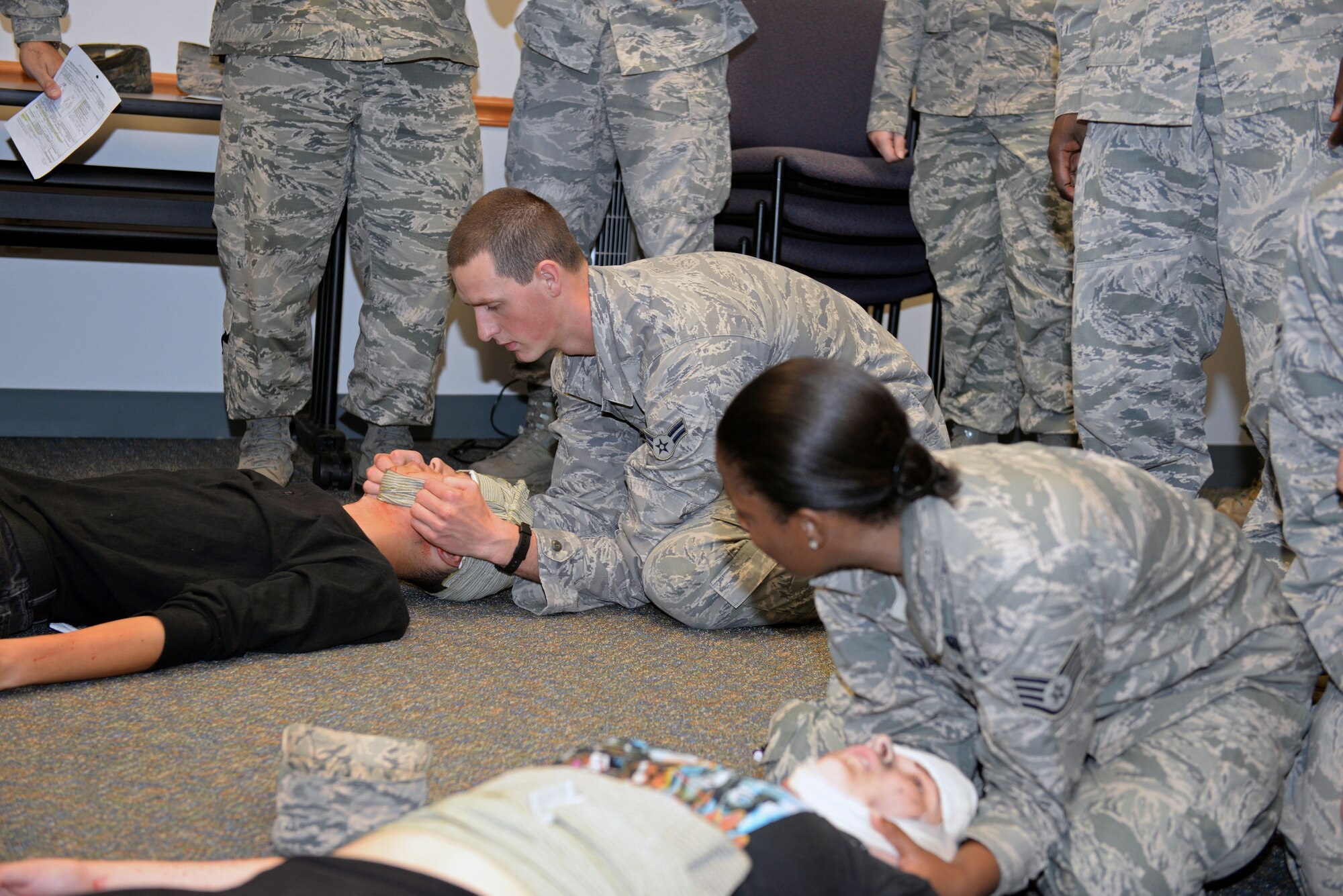 Airmen practice opening the airway of a patient during Self-Aid & Buddy Care training for 375th Communications Group members at the Education Center, Scott Air Force Base, Ill., Sept.8, 2014. This move is called the jaw thrust, and it is done when there is a concern the patient has a spinal injury. These 150 personnel fulfilled their requirement of SABC training to be deployment-ready. (U.S. Air Force photo by Airman 1st Class Erica Crossen)