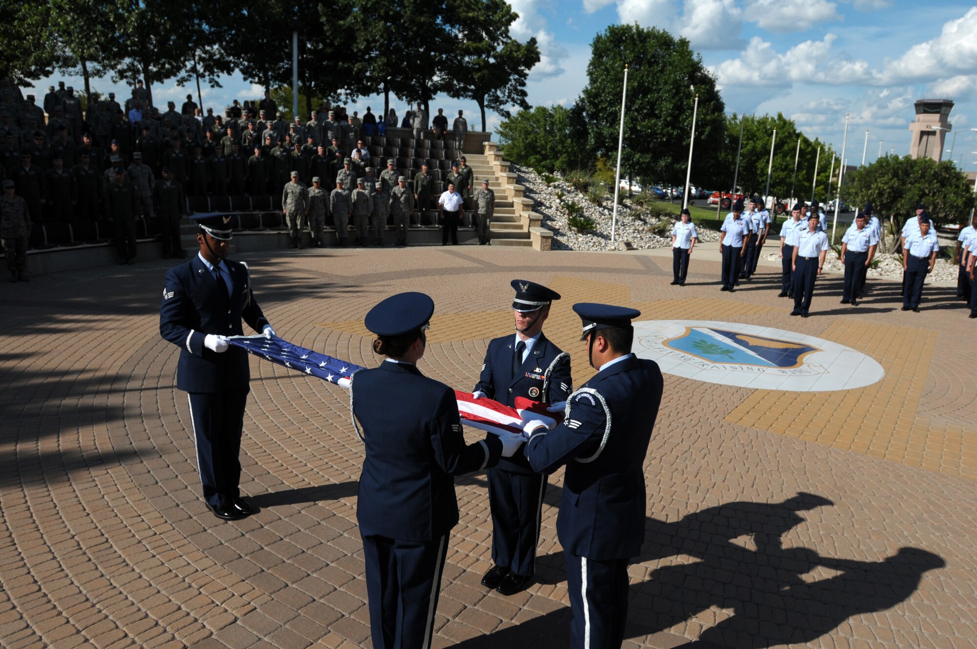 Laughlin Air Force Base Honor Guardsmen ceremoniously fold the installation flag at a Sept. 11 remembrance retreat ceremony on Laughlin Air Force Base, Texas, Sept. 11, 2014. The flag is carefully folded into the shape of a tri-cornered hat, emblematic of the hats worn by colonial soldiers during the war for Independence, and the red and white stripes are wrapped into the blue, as the light of day vanishes into the darkness of night. (U.S. Air Force photo by Staff Sgt. Steven R. Doty)(Released)