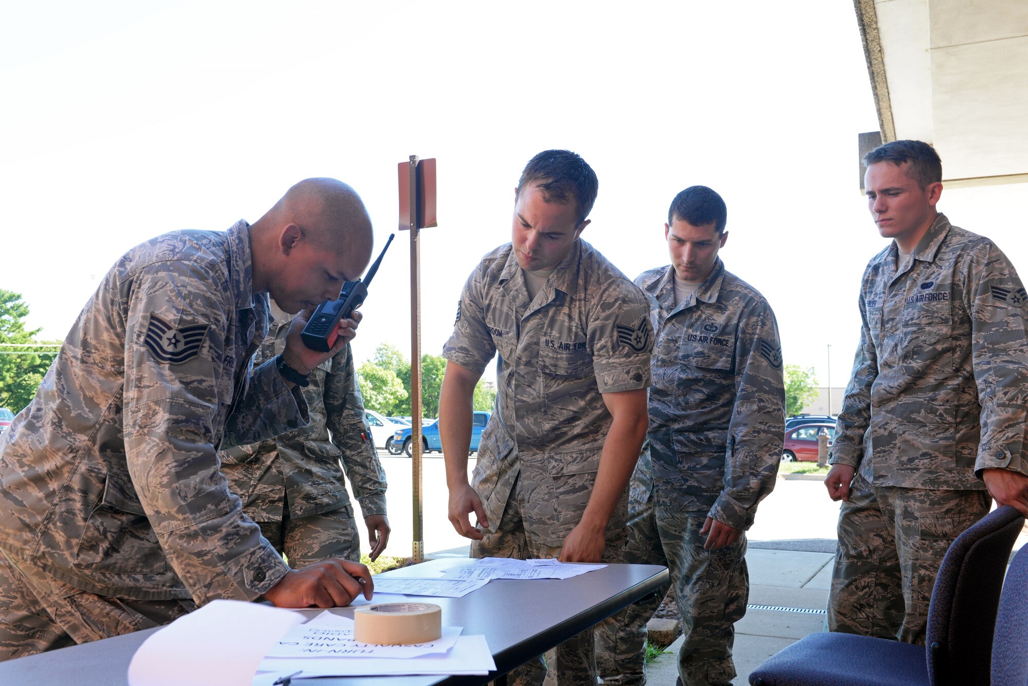 375th Communications Group Airmen practice 9-line reporting to the 375 CG Unit Control Center at the conclusion of their Self-Aid & Buddy Care training at the Education Center, Scott Air Force Base, Ill., Sept. 8, 2014. The Airmen encountered and tended to simulated victims who had a variety of 'injuries', including head injuries, severe bleeding requiring tourniquets, broken bones, and amputations. These 150 personnel, through this training, fulfilled their requirement of SABC training to be deployment-ready. (U.S. Air Force photo by Airman 1st Class Erica Crossen)