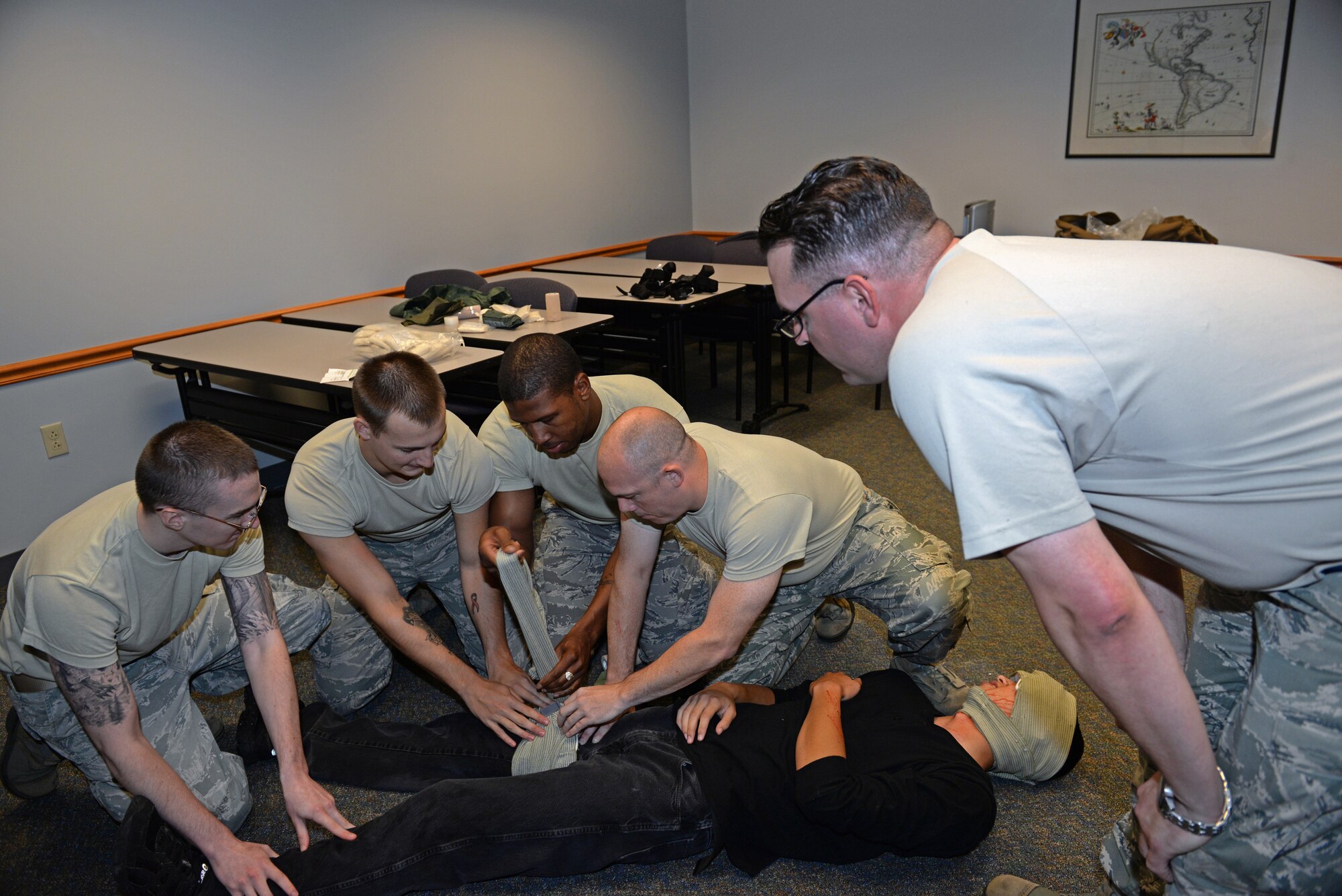 375th Communications Group Airmen put two to three minutes of pressure on a simulated wound of a victim during Self-Aid & Buddy Care training at the Education Center, Scott Air Force Base, Ill., Sept. 8, 2014. The Airmen encountered and tended to simulated victims who had a variety of 'injuries', including head injuries, severe bleeding requiring tourniquets, broken bones, and amputations. These 150 personnel, through this training, fulfilled their requirement of SABC training to be deployment-ready. (U.S. Air Force photo by Airman 1st Class Erica Crossen)