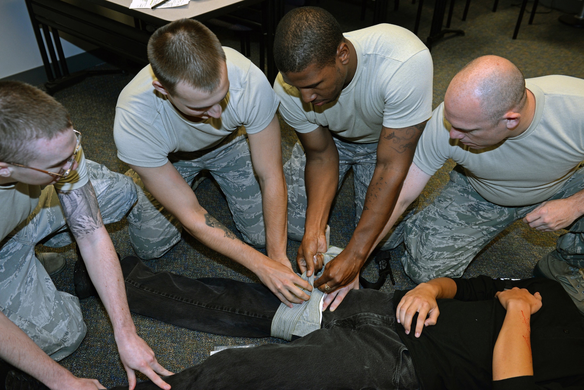 375th Communications Group Airmen put two to three minutes of pressure on a simulated wound of a victim during Self-Aid & Buddy Care training at the Education Center, Scott Air Force Base, Ill., Sept. 8, 2014. The Airmen encountered and tended to simulated victims who had a variety of 'injuries', including head injuries, severe bleeding requiring tourniquets, broken bones, and amputations. These 150 personnel, through this training, fulfilled their requirement of SABC training to be deployment-ready. (U.S. Air Force photo by Airman 1st Class Erica Crossen)