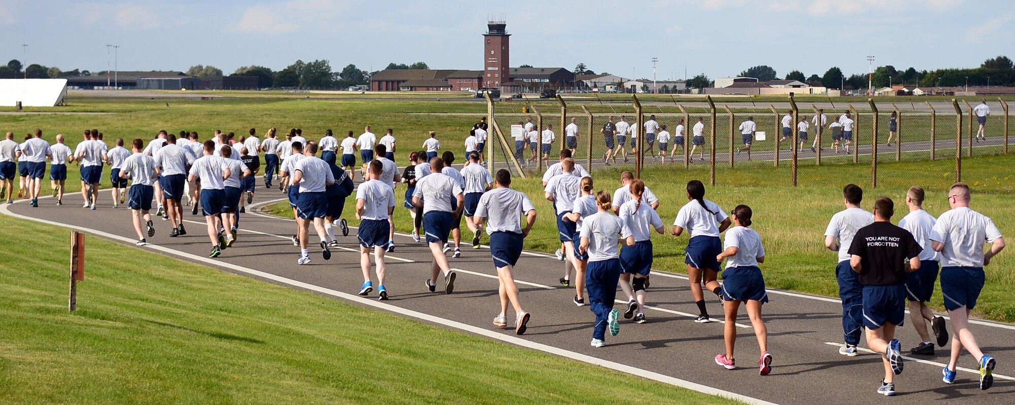 Team Mildenhall members pace each other during the 100th Air Refueling Wing 5 km run in honor of Prisoner of War/Missing in Action Week of Remembrance Sept. 12, 2014, on RAF Mildenhall, England. Every month, Team Mildenhall members gather for exercise and friendly competition. (U.S. Air Force photo/Airman 1st Class Jonathan Light/Released)