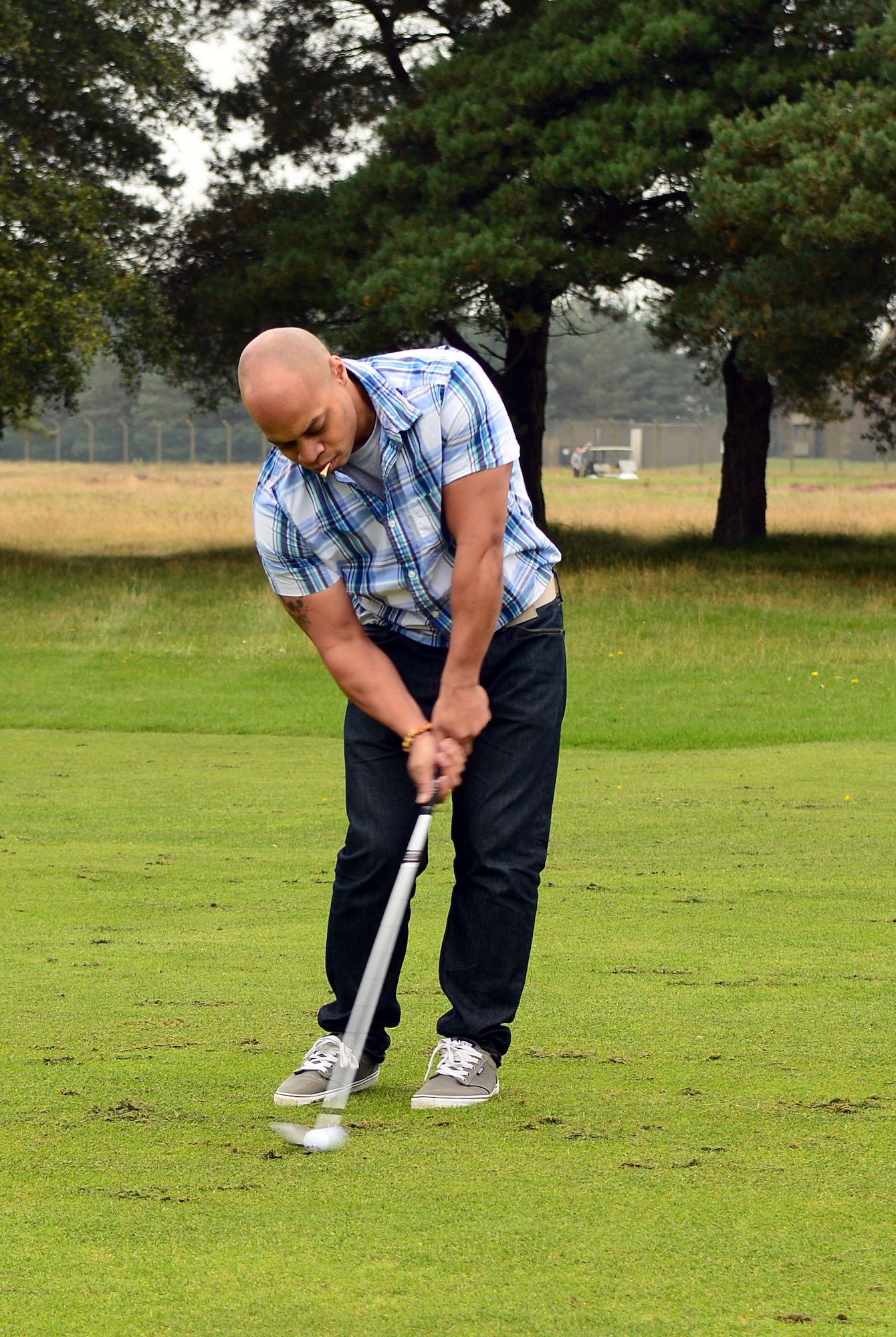 U.S. Air Force Senior Airman Thomas Hull, 38th Reconnaissance Squadron Airborne Systems engineer assigned to Offutt Air Force Base, Neb. and from Detroit, chips a golf ball during a Combined Federal Campaign golf tournament Sept. 11, 2014, at the Breckland Pines Golf Club on RAF Lakenheath, England.  The campaign is an annual federal fundraiser benefitting nonprofit charity organizations.. (U.S. Air Force photo/Airman 1st Class Jonathan Light/Released)