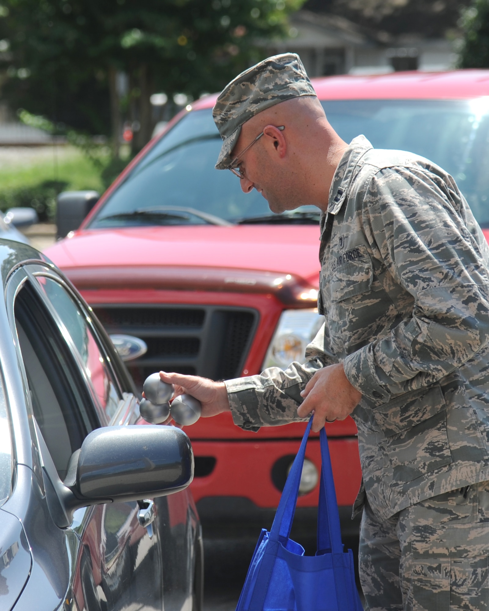 Capt. Adam Dell, 81st Medical Operations Squadron, hands out suicide prevention awareness stress balls to Keesler personnel as they enter the base Sept. 10, 2014, at Keesler Air Force Base, Miss. This task was in recognition of suicide prevention awareness.  (U.S. Air Force photo by Kemberly Groue)