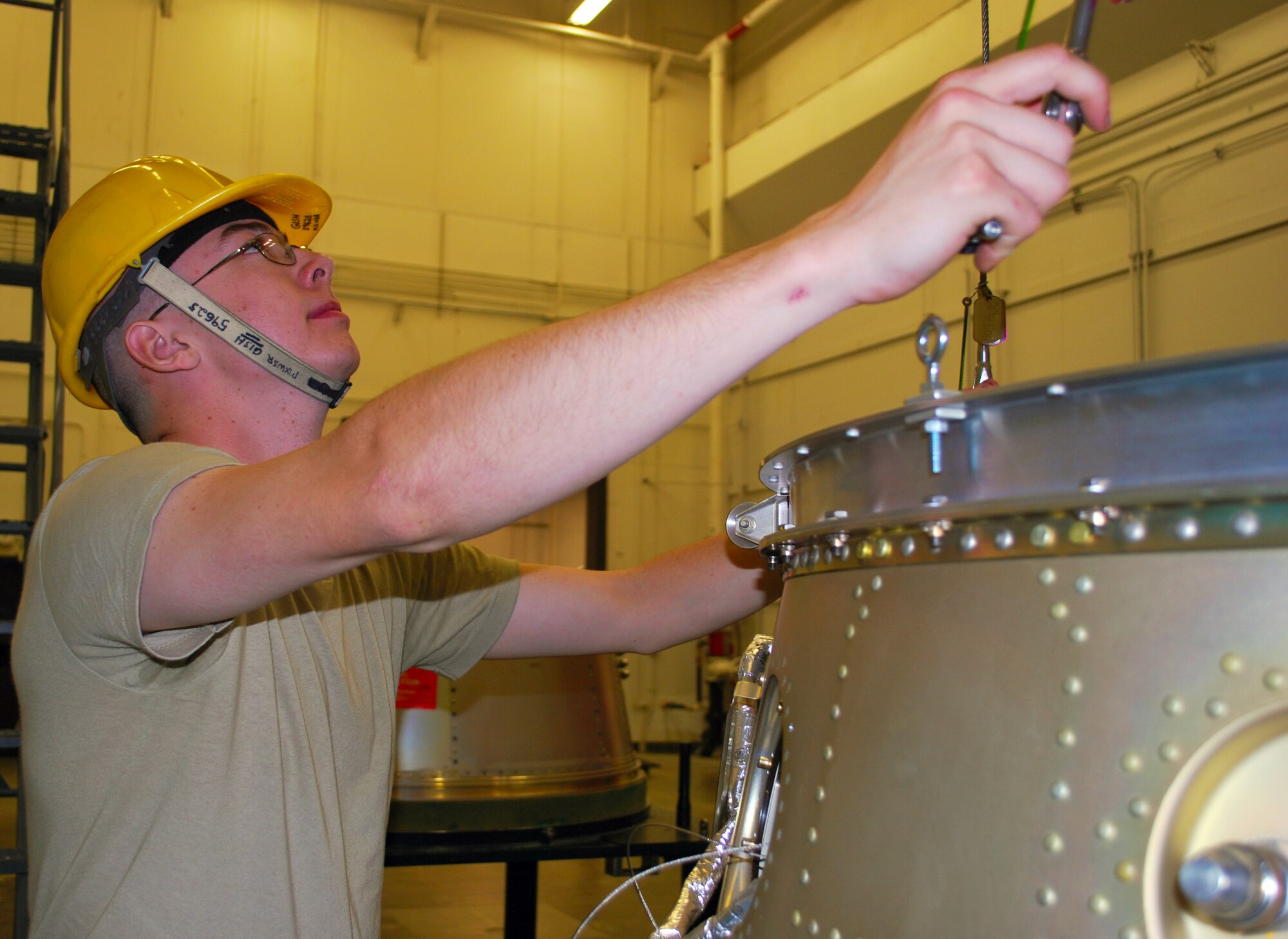 Airman 1st Class Matthew Gish, 341st Munitions Squadron technician, holds a lifting adapter while getting ready to hoist a payload during a training session at Malmstrom Air Force Base Aug. 21. Gish is one of four Airmen that will represent Wing One’s Munitions Squadron during the 2014 Global Strike Challenge. (U.S. Air Force photo/Airman 1st Class Collin Schmidt)