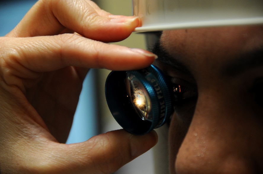 U.S. Air Force Capt. Roxanne Buffano, 927th Aersospace Medicine Squadron optometrist, conducts an exam with a diagnostic fundus lens at her civilian practice near Plant City, Fla, Sept. 11, 2014. Bufano, a traditional reservist with the wing, utilizes the same technology during unit training assemblies. (U.S. Air Force photo/Senior Airman Xavier Lockley)