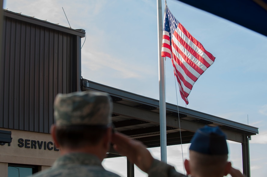 Moody commanders salute for the posting of the colors as the United States flag is raised at half staff during a 9/11 remembrance ceremony Sept. 11, 2014, Moody Air Force Base, Ga. The flag at half staff is a symbol of respect for the 2,945 men and women who lost their lives on 9/11. (U.S. Air Force photo by Airman 1st Class Dillian Bamman/Released)