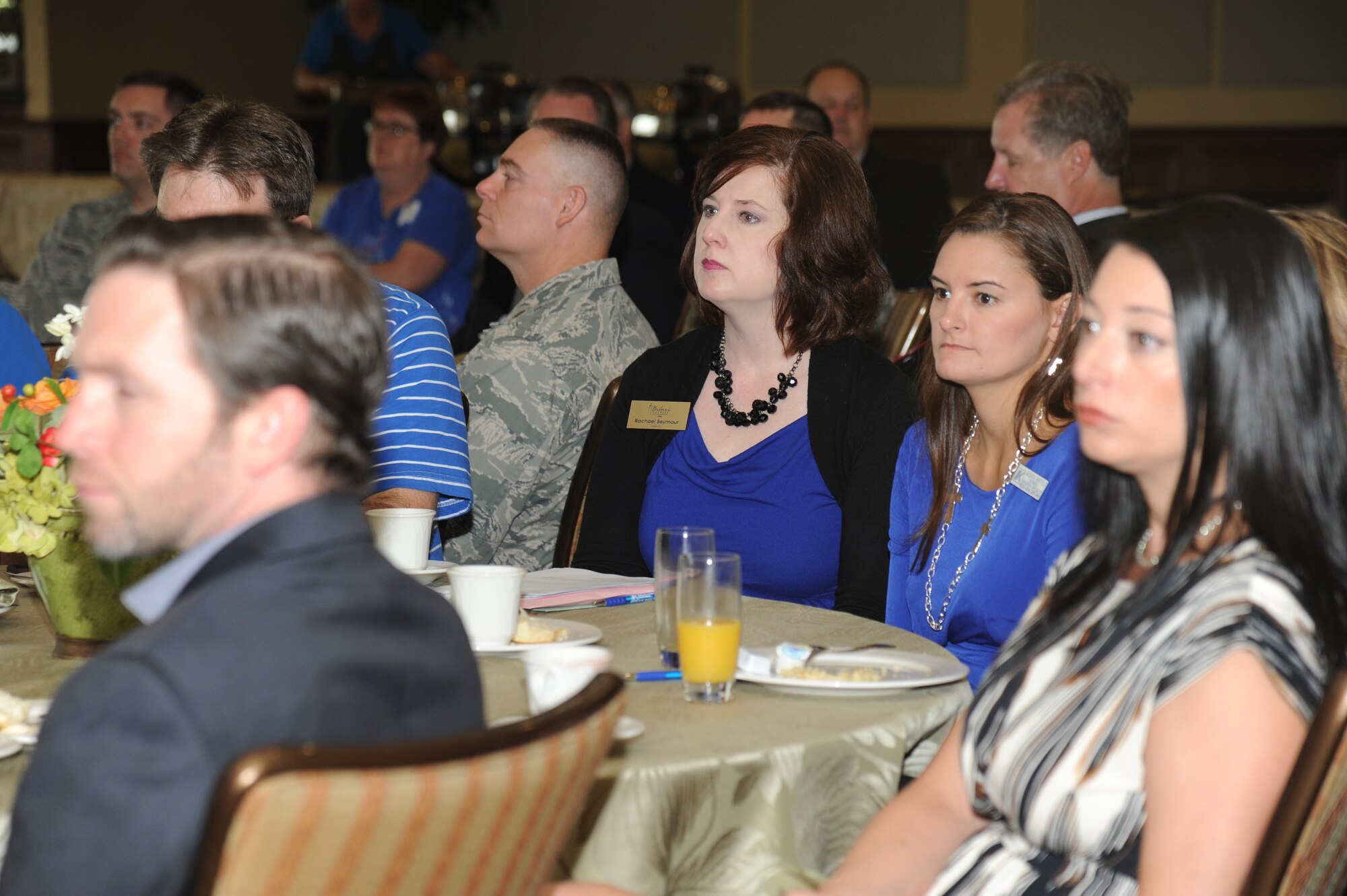 Rachel Seymour, Biloxi Chamber of Commerce director, and Jessica Bartells, Keesler federal Credit Union business development manager, sit among Keesler personnel and local community members, listening to keynote speakers during the Biloxi Chamber of Commerce Morning Call Sept. 10, 2014, hosted by Keesler Air Force Base, Miss., at the Bay Breeze Event Center. (U.S. Air Force photo by Kemberly Groue)