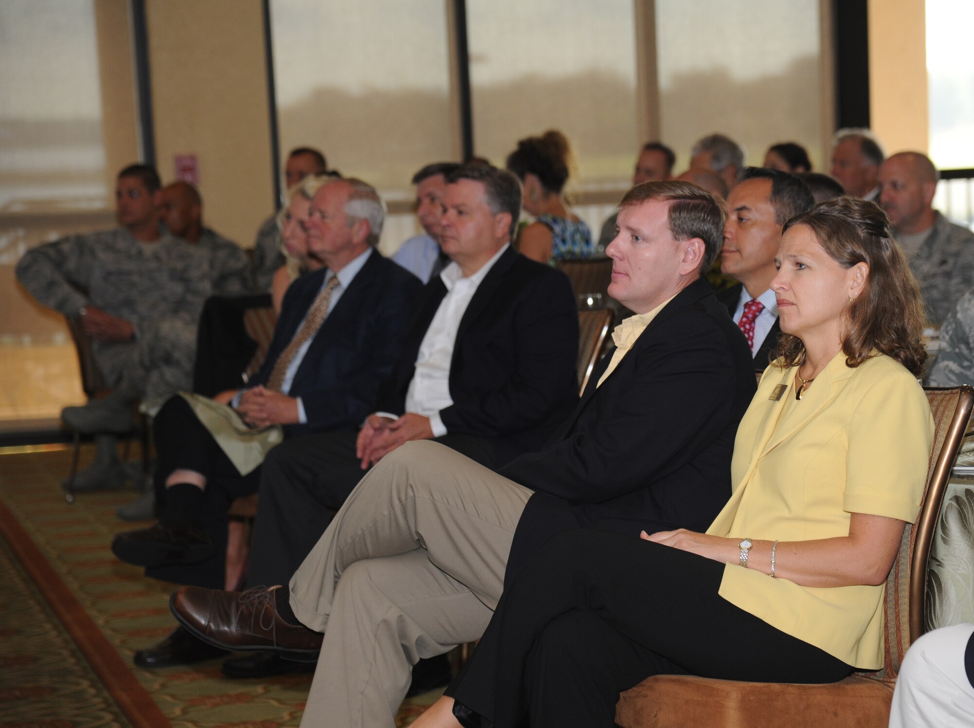 Jason Manley, Mississippi Power coast division manager, and Hilary Eisbrenner, Keesler Federal Credit Union chief financial officer, listen to keynote speakers during the Biloxi Chamber of Commerce Morning Call Sept. 10, 2014, hosted by Keesler Air Force Base, Miss., at the Bay Breeze Event Center. (U.S. Air Force photo by Kemberly Groue)