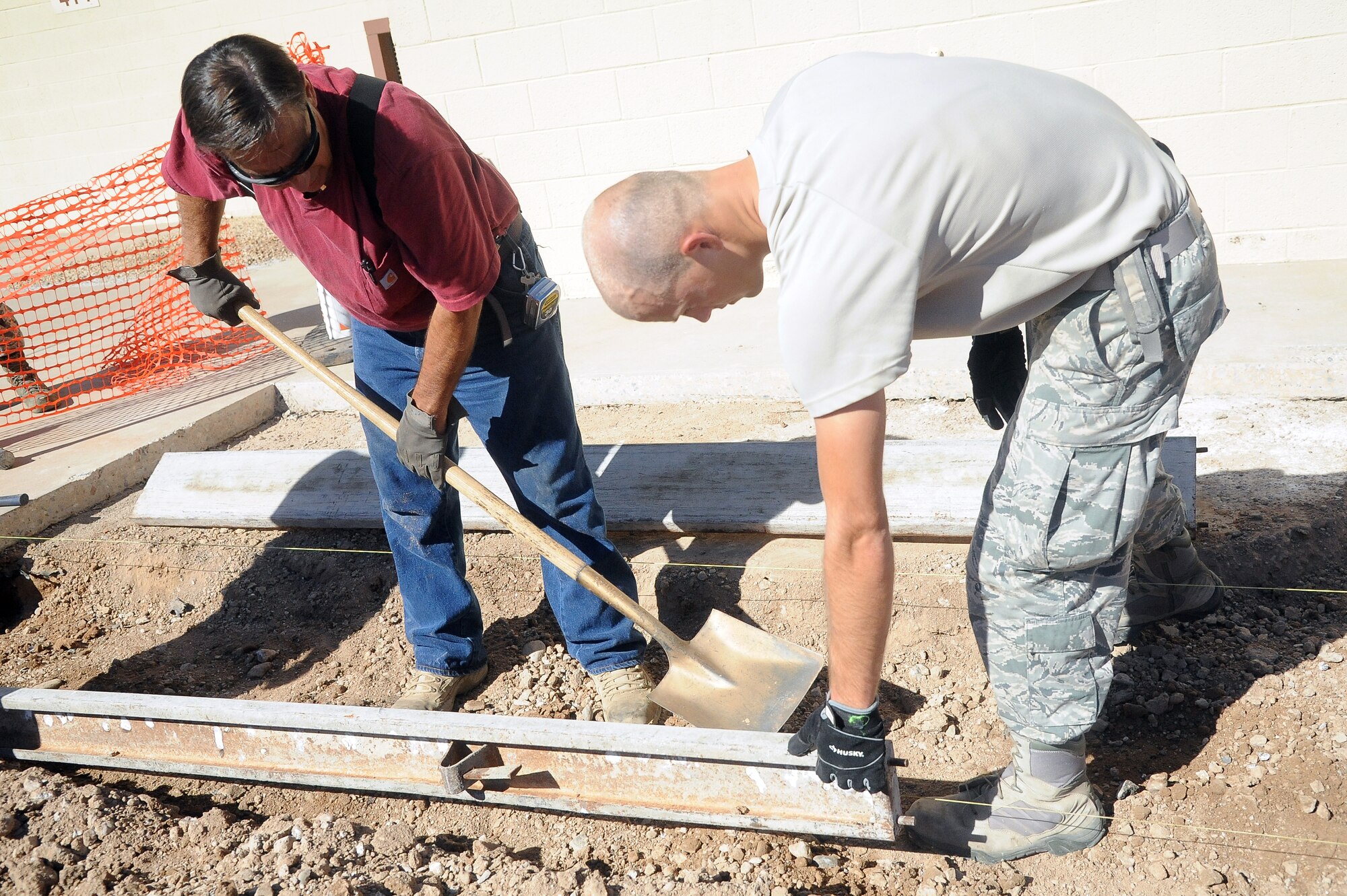 William St. Bernard, 56th Civil Engineer Squadron engineering equipment operator, and Airman 1st Class Daniel Zimmerman, 56th CES Structure, fixes and replaces concrete in sidewalk gutters Sept. 3 at Luke Air Force Base. (U.S. Air Force photo/Airman 1st Class Pedro Mota)