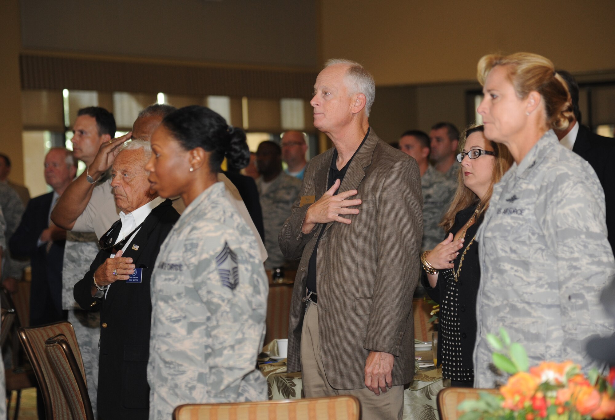 Damon Penny, Biloxi Chamber of Commerce board member, places his hand over his heart as the National Anthem is sung during the Biloxi Chamber of Commerce Morning Call Sept. 10, 2014, hosted by Keesler Air Force Base, Miss., at the Bay Breeze Event Center.  (U.S. Air Force photo by Kemberly Groue)