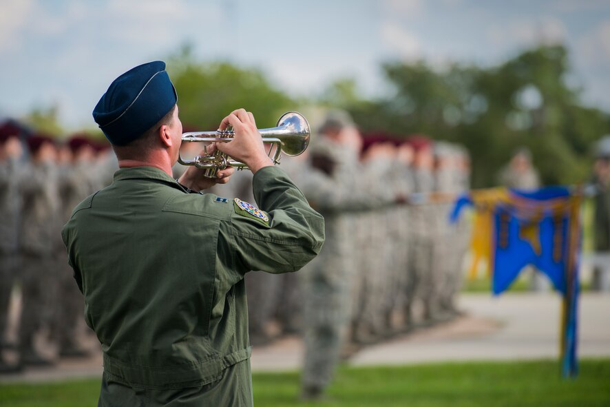 U.S. Air Force Capt. James Schmidt, 74th Fighter Squadron A-10C Thunderbolt II pilot, plays the National Anthem during a 9/11 remembrance ceremony Sept. 11, 2014, at Moody Air Force Base, Ga. Airmen gathered around the flagpole for the playing of retreat and to honor the 2,945 lives lost as a consequence of the Sept. 11 terrorist attacks and resulting conflicts. (U.S. Air Force photo by Airman 1st Class Ryan Callaghan/Released)