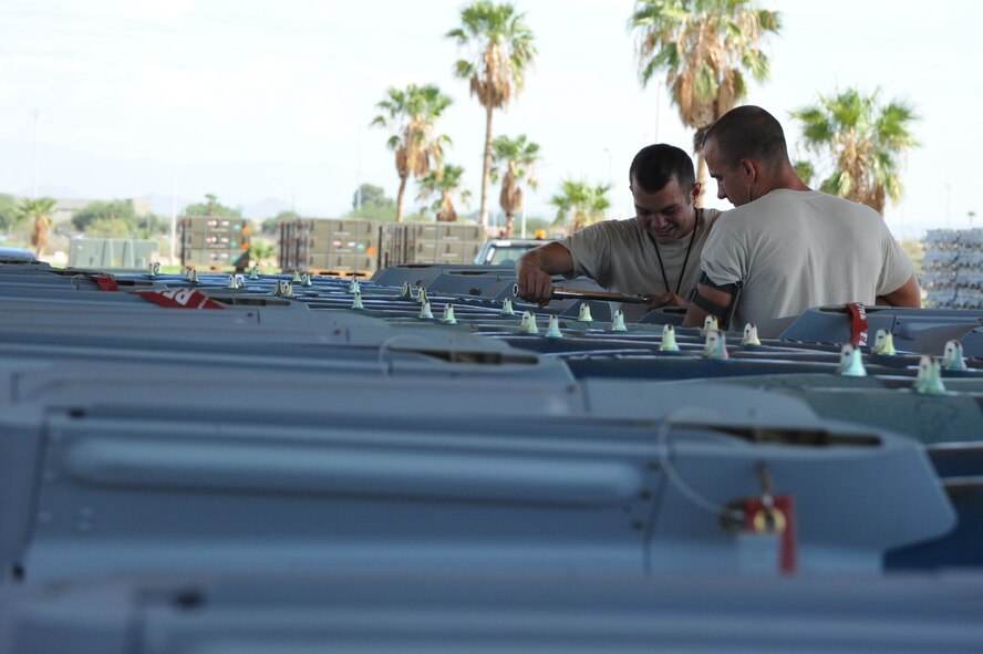 FROM LEFT: Staff Sgts. Corey Cobb and Kenneth Coderre, 56th EMS conventional maintenance crew members, attach airfoils to guided bomb unit-12s at Luke. GBU-12s are laser designated bombs and one of many munitions weapon maintainers handle. (U.S. Air Force photo/Airman 1st Class James Hensley)