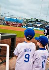 Young volunteers joined Airmen from Whiteman Air Force Base to participate in the 9/11 memorial flag ceremony at the Kansas City Royals baseball game on Sept. 11, 2014. Airmen participated from the 442 Fighter Wing, 509 Bomb Wing and other units across the base. (Photo by Tech. Sgt. Emily F. Alley, 442FW public affairs)