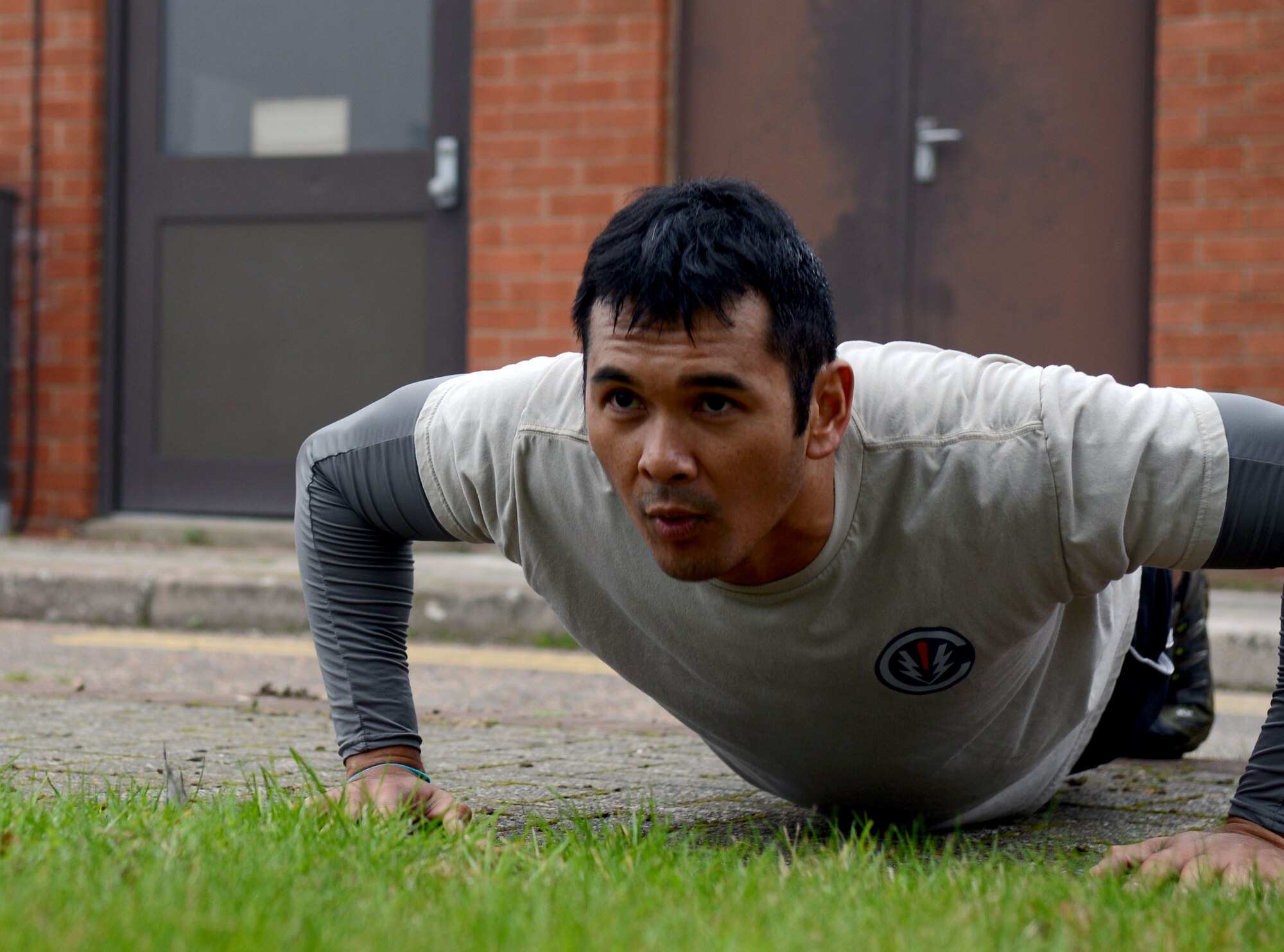 U. S. Air Force Capt. Jethro Sadorra, 352nd Special Operations Group civil engineer, from Monterey, Calif., completes push-ups Sept. 11, 2014, on RAF Mildenhall England. After participating in a 9/11 Memorial Ruck, Airmen  from the 352nd SOG completed push-ups in honor of the fallen men and women of the attacks on Sept. 11th, 2001. (U.S. Air Force photo/Airman 1st Class Kyla Gifford/Released)