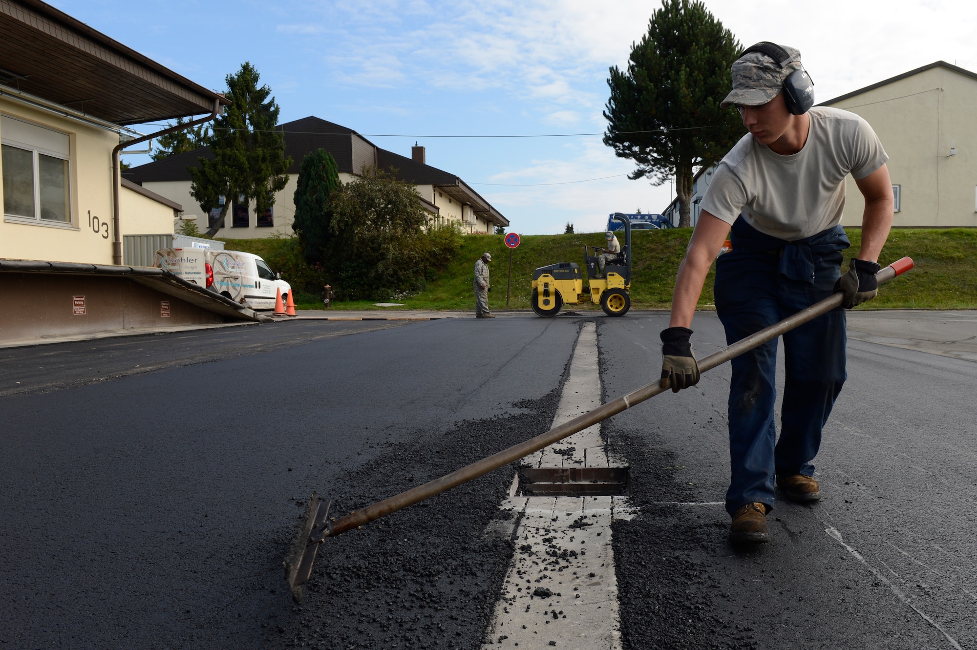 U.S. Air Force Senior Airman Stephen Zemke, 52nd Civil Engineer Squadron pavement and equipment journeyman from Hilo, Hawaii, refines the edge of the freshly laid asphalt during a road repair at Spangdahlem Air Base, Germany, Sept. 12, 2014. The 52nd CES pavement and heavy equipment operators maintain and repair concrete and asphalt on Spangdahlem roadways and flightline. (U.S. Air Force photo by Staff Sgt. Christopher Ruano/Released)