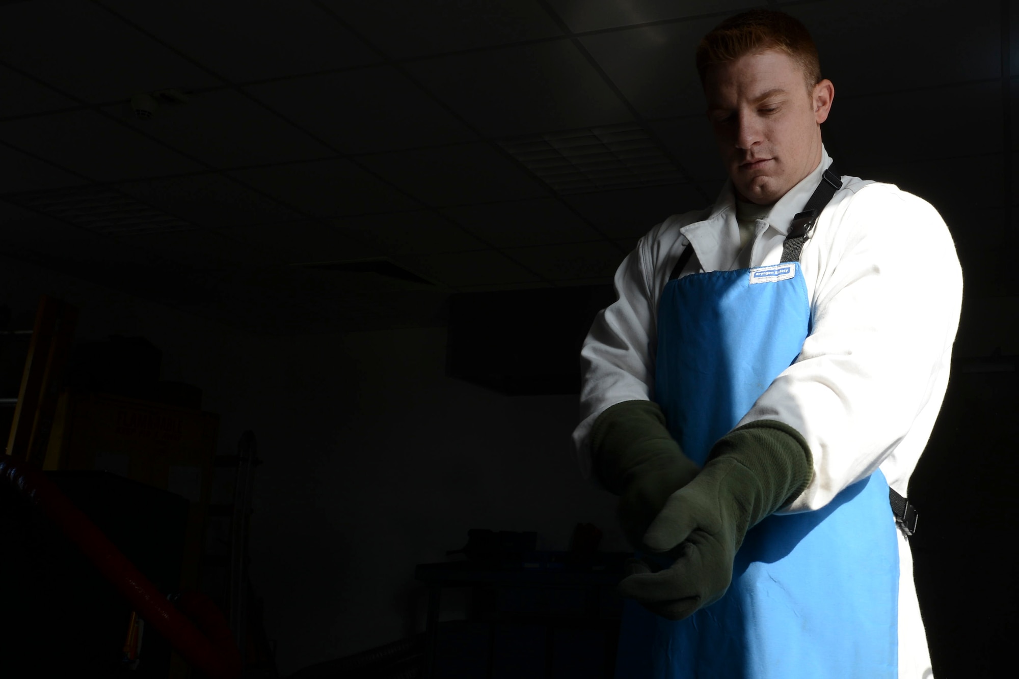 Senior Airman Jeffery Halda, 86th Logistics Readiness Squadron hydrants technician, puts on personal protective equipment to ensure safe procedures while handling liquid oxygen on Ramstein Air Base, Germany, Sept. 3, 2014. Liquid oxygen is primarily used as breathing oxygen for aircrew members during flights and is stored at -297 degrees Fahrenheit. (U.S. Air Force photo/Airman 1st Class Michael Stuart)