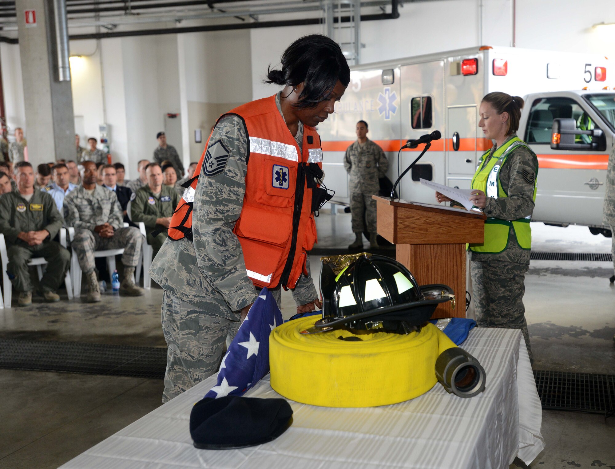 Master Sgt. Kelly Randolph, 31st Aerospace Medical Squadron NCO in charge of ambulance services, places an emergency medical services vest on a memorial table during a 9/11 remembrance ceremony, Sept. 11, 2014, at Aviano Air Base, Italy. The ceremony began with the presentation of the colors; saying of the firefighter, police officer and EMS prayers; and a flag folding ceremony. (U.S. Air Force photo/Airman 1st Class Deana Heitzman)