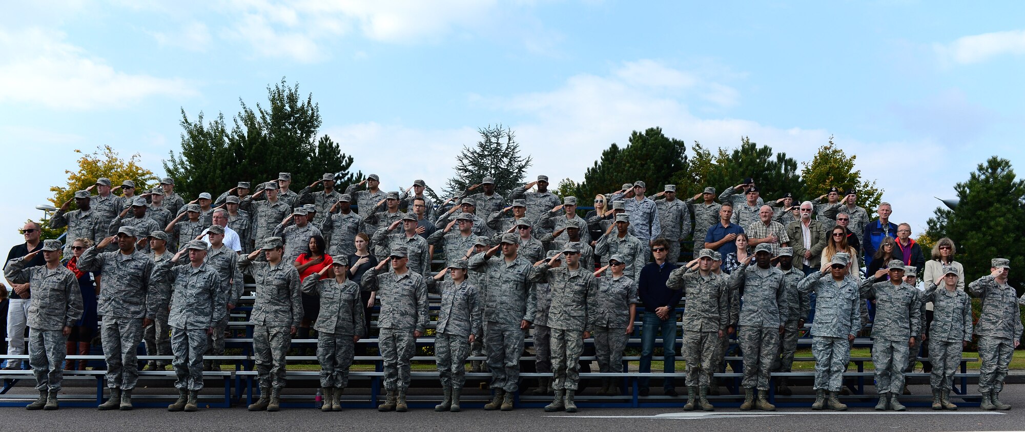 Airmen and civilians stand during the singing of the national anthem at a 9/11 ceremony at the Spangdahlem Air Park Memorial Sept. 11, 2014, at Spangdahlem Air Base, Germany.  The ceremony had more than 200 Airmen and Germans in attendance. (U.S. Air Force Photo by Airman 1st Class Luke J. Kitterman/Released)