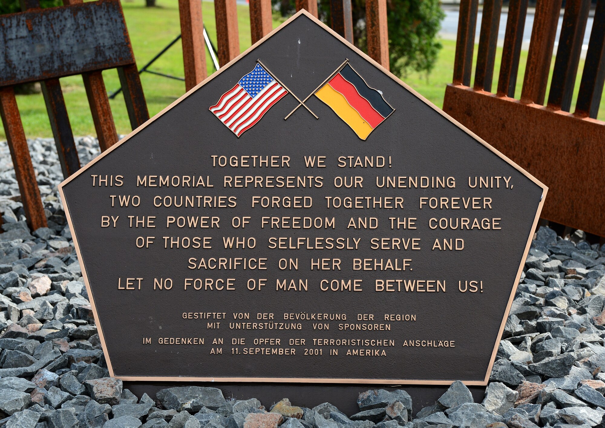 The 9/11 ceremony takes place at the Spangdahlem Air Park Memorial Sept. 11, 2014, at Spangdahlem Air Base, Germany. This plaque is part of a memorial statue designed by Hubert Kruft and signifies strength and unity. He, along with the Host Nation Council Spangdahlem e.V., donated the memorial to the men and women of the 52nd Fighter Wing. (U.S. Air Force Photo by Airman 1st Class Luke J. Kitterman/Released)