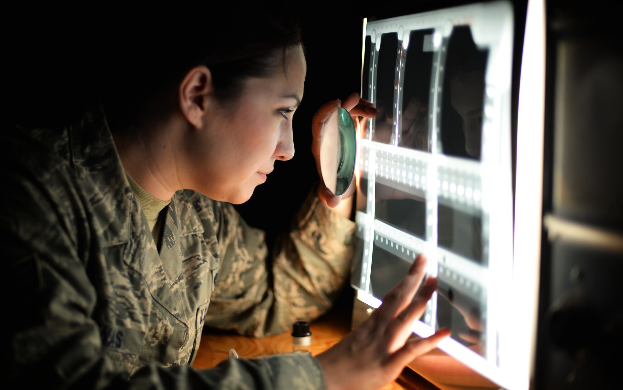 Senior Airman Jessica Salinas, 48th Equipment Maintenance Squadron nondestructive inspection journeyman, examines x-ray film of an F-15 fighter jet component on Royal Air Force Lakenheath, England, Sep. 10, 2014. NDI Airmen are able to inspect aircraft for defects without completely having to deconstruct them, saving valuable time and money.  (U.S. Air Force photo by Staff Sgt. Emerson Nuñez/Released)