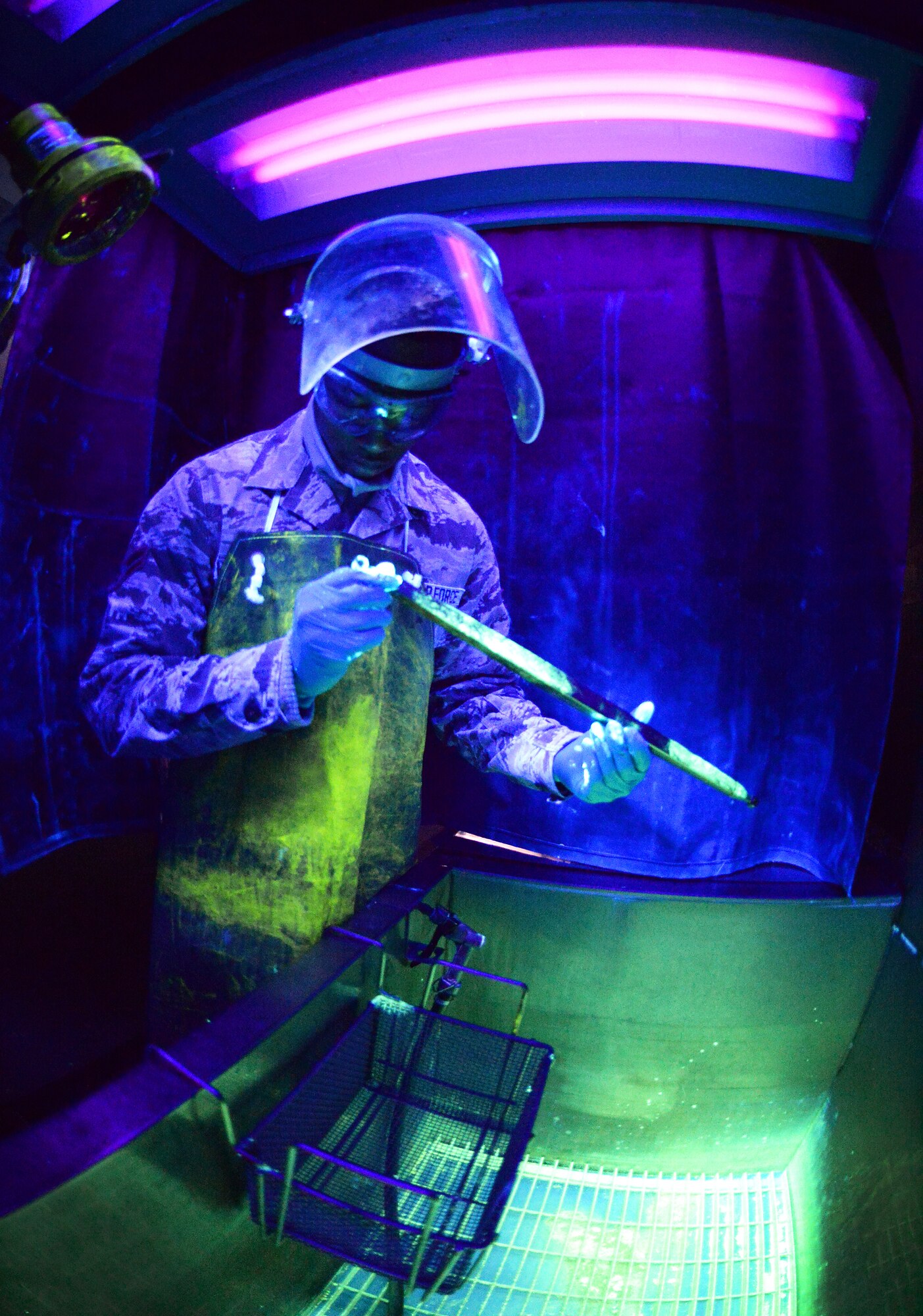 Airman 1st Class Dontea Haliburton, 48th Equipment Maintenance Squadron nondestructive inspection journeyman, performs a fluorescent penetrant inspection on an engine component on Royal Air Force Lakenheath, England, Aug. 12, 2014. NDI Airmen are tasked with ensuring aircraft and weapons systems parts are structurally safe with no damage, flaws, heat damage or stress fractures. (U.S. Air Force photo by Staff Sgt. Emerson Nuñez/Released)