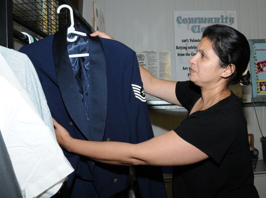 Mara Miller, a volunteer from Honduras and wife of Scott Miller, Joint Special Operations Air Component–Europe, Deputy J3 from Las Vegas, displays donated military uniforms Sept. 10, 2014, in the community closet on RAF Mildenhall, England. The condition of receiving items from the community closet is that the item can’t be sold, and once no longer needed, it can be brought back if in a usable condition. (U.S. Air Force photo/Gina Randall/Released)