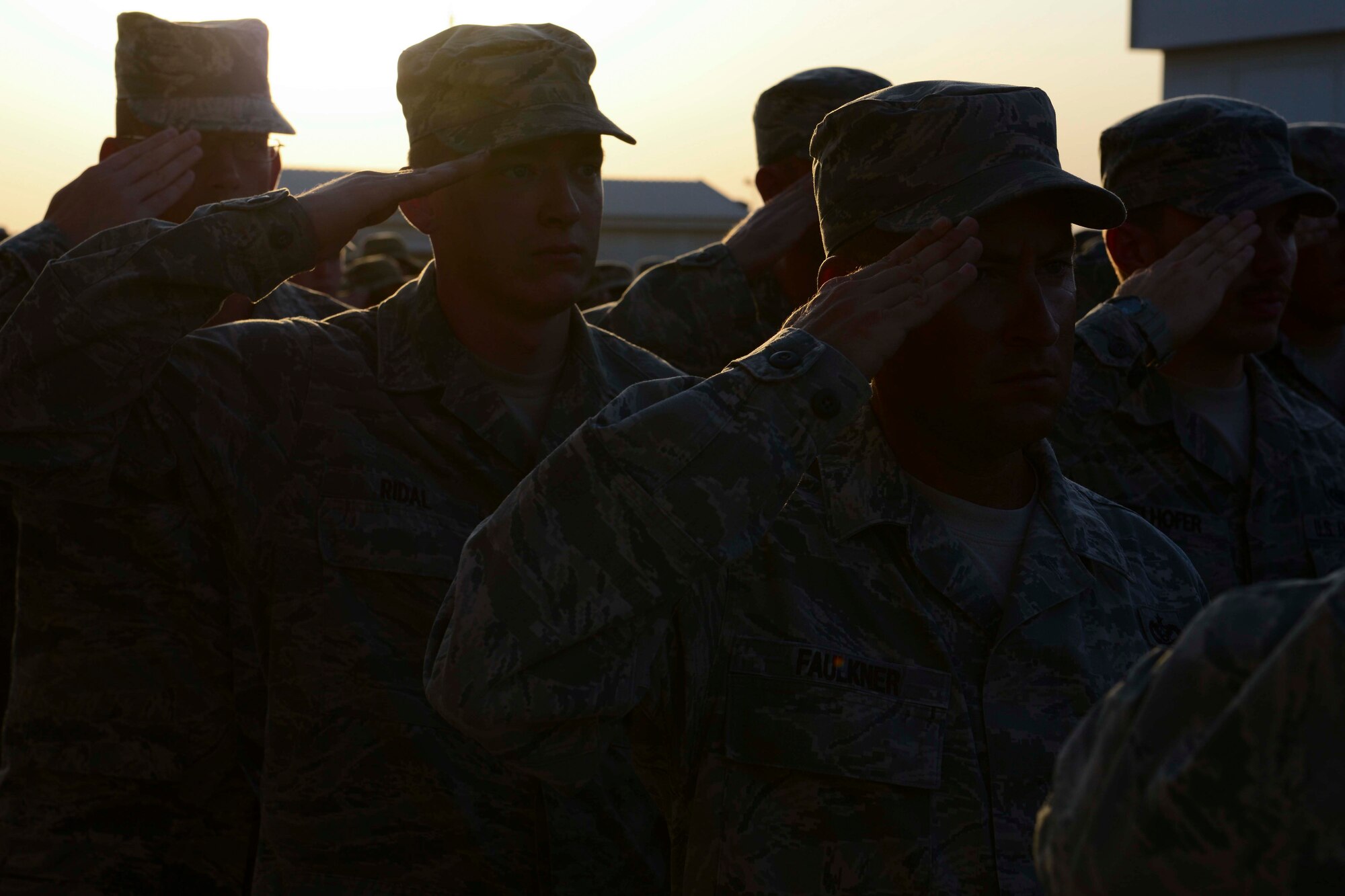 U.S. Air Force Airmen salute during a retreat ceremony in honor of the thirteenth anniversary of Sept. 11, 2001, at Al Udeid Air Base, Qatar, Sept. 11, 2014. The event was held to honor and remember those who lost their lives on that day more than a decade ago. (U.S. Air Force photo by Staff Sgt. Ciara Wymbs)