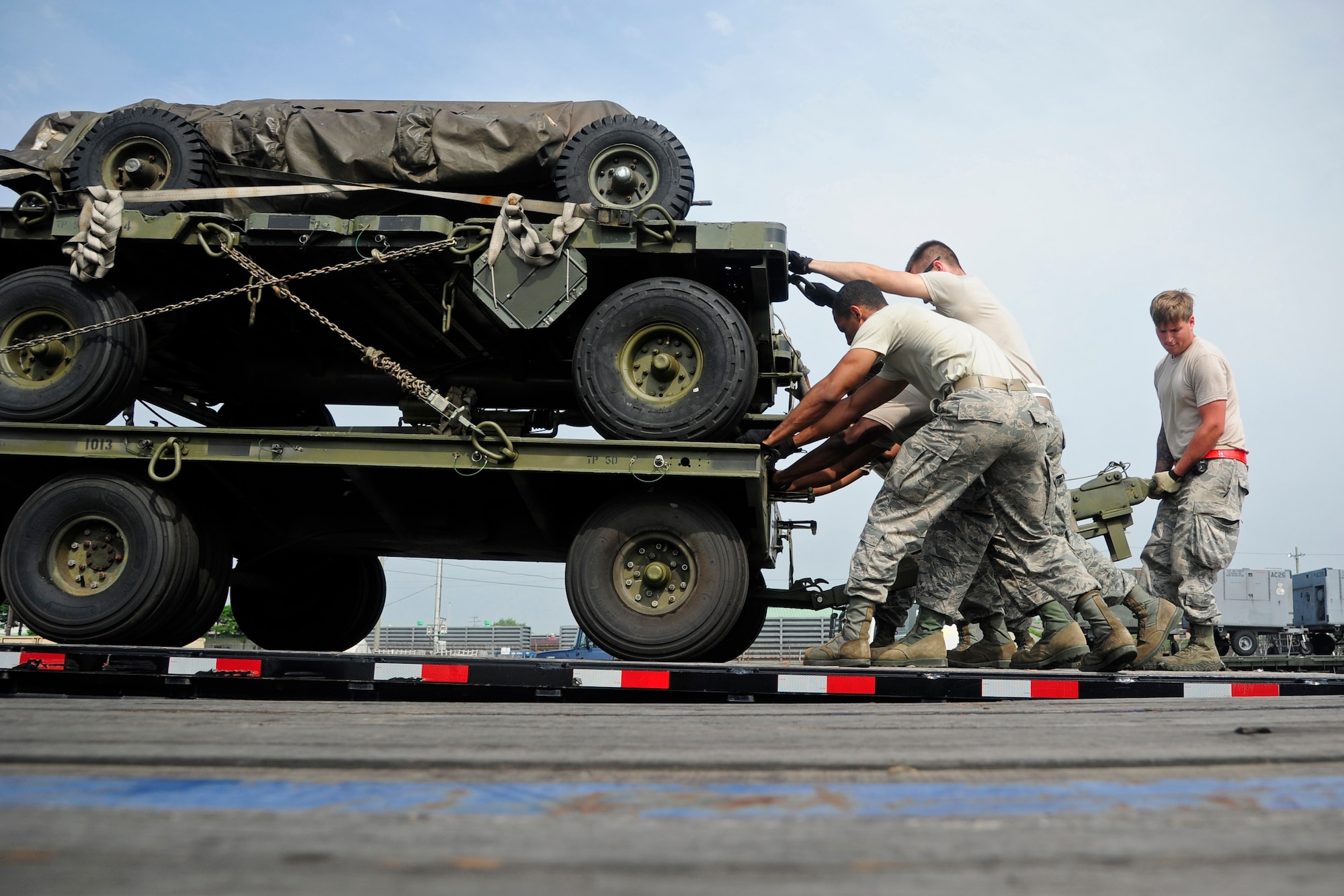 Airmen from the 8th Logistics Readiness Squadron load cargo onto a long-bed truck at Kunsan Air Base, Republic of Korea, Sept. 9, 2014. The equipment is being sent to Osan AB to support 8th Fighter Wing flying operations while the runway at Kunsan undergoes construction. (U.S. Air Force photo by Senior Airman Taylor Curry/Released)