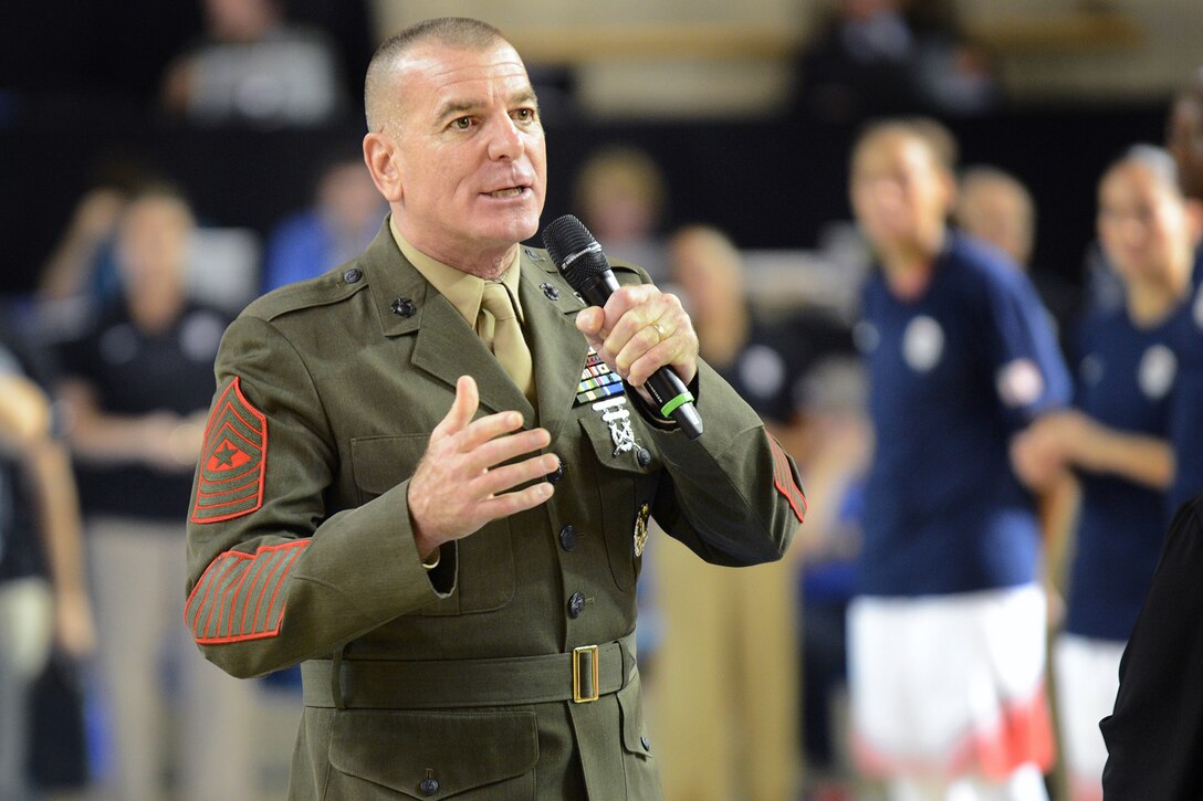 Marine Corps Sgt. Maj. Bryan B. Battaglia, the senior enlisted advisor to the chairman of the Joint Chiefs of Staff, addresses the audience as U.S. military personnel and the U.S. Women's National Basketball Team exchange “dog tags” and coins at the University of Delaware, Sept. 11, 2014. DoD photo by Marvin Lynchard