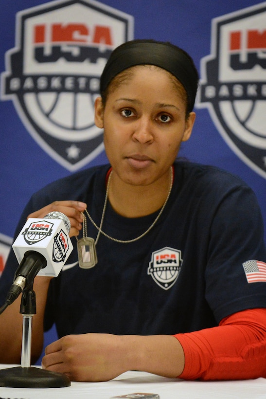 Maya Moore, a star player in the Women’s National Basketball Association and a member of the U.S. Women's National Basketball Team, displays her “dog tag” during a post-game press conference at the University of Delaware, Sept. 11, 2014. The women’s USA basketball team played an inter-squad exhibition game at the University of Delaware. Military personnel and the basketball team exchanged “dog-tags” and coins during a halftime ceremony. DoD photo by Marvin Lynchard