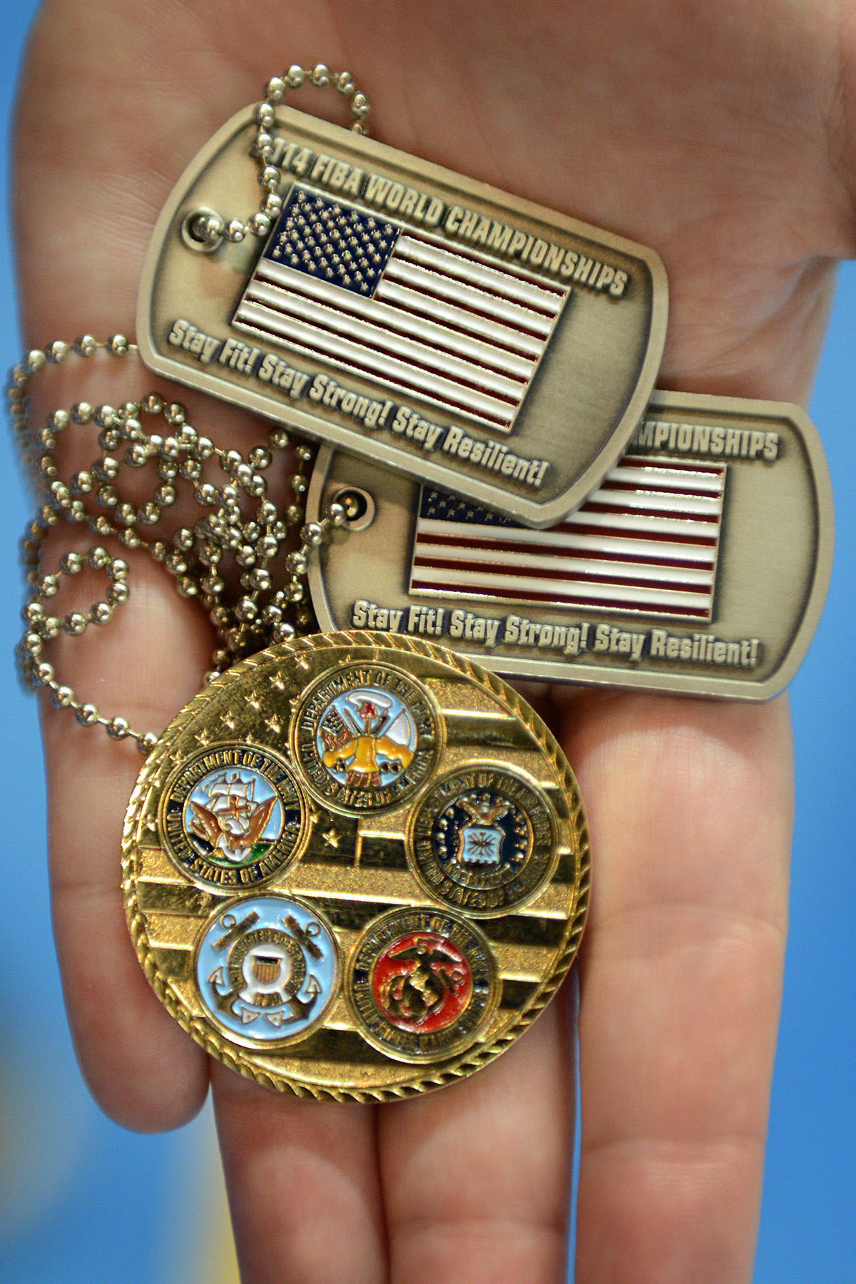 A Hand Holds Some Of The Dog Tags And Commemorative Coins That