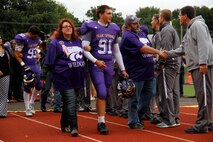 Jaycee D. Pummill, the Blue Springs High School senior long snapper and a 2015 Semper Fidelis All-American Bowl selectee, walks with his parents, Dan and Cindy Pummill, during the Wildcats' senior night before their game against the St. Joseph Central High School Indians at Peve Stadium Sept. 12, 2014. Pummill was ranked 11th overall in snapping by Kohl’s Professional Camps for the 2015 class. He is one of approximately 100 players selected from across the nation to participate in the Semper Fi Bowl next year at the StubHub Center in Carson, Calif.,  on Jan. 4, 2015, and will be aired live on Fox Sports 1 at 6 p.m. Pacific Standard Time.