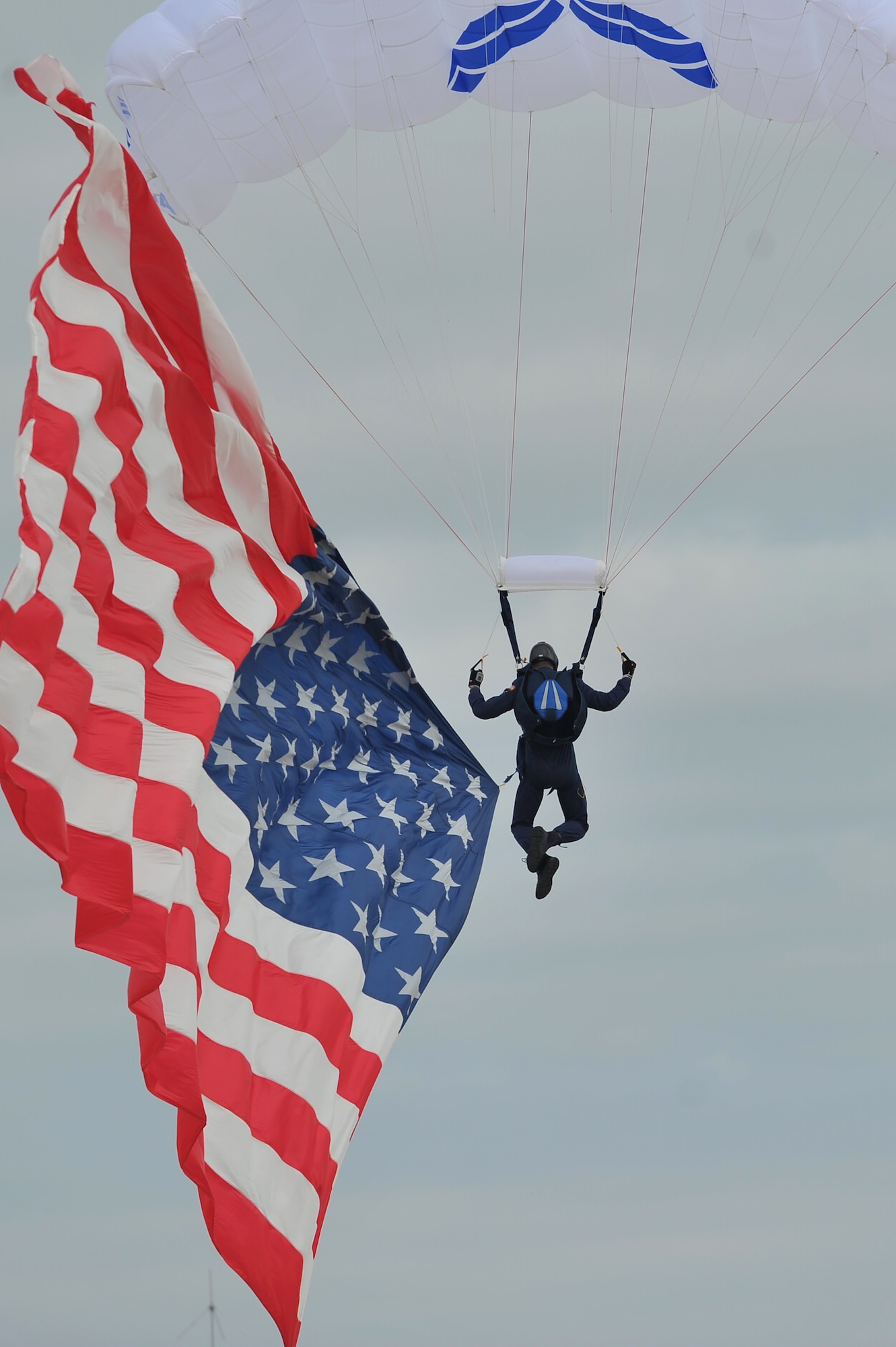 ALTUS AIR FORCE BASE, Okla. – A member of the U.S. Air Force Academy Wings of Blue parachute demonstration team presents the U.S. flag during the 2014 Wings of Freedom Open House, Sept. 13, 2014. The Wings of Blue demonstration team travels across the country to airshows, sporting events, and other venues to represent the Air Force in precision parachuting. (U.S. Air Force photo by Senior Airman Dillon Davis/Released)