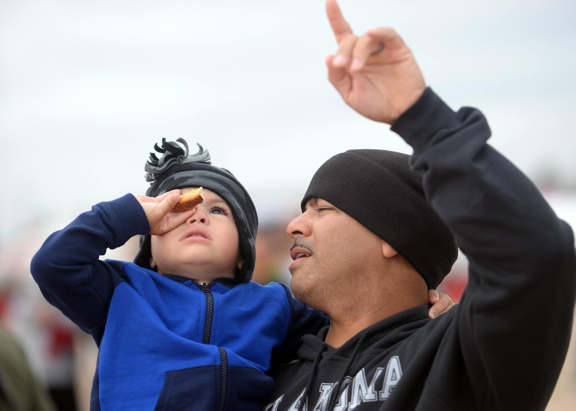 ALTUS AIR FORCE BASE, Okla. – Harby Perez points out the U.S. Air Force Academy Wings of Blue to his son, Jovanni, during the 2014 Wings of Freedom Open House, Sept. 13, 2014. The U.S. Air Force Academy Wings of Blue Parachute Team demonstrated their aerial skills with high speed free falling maneuvers and precision canopy flight. (U.S. Air Force photo by Senior Airman Levin Boland/Released)  