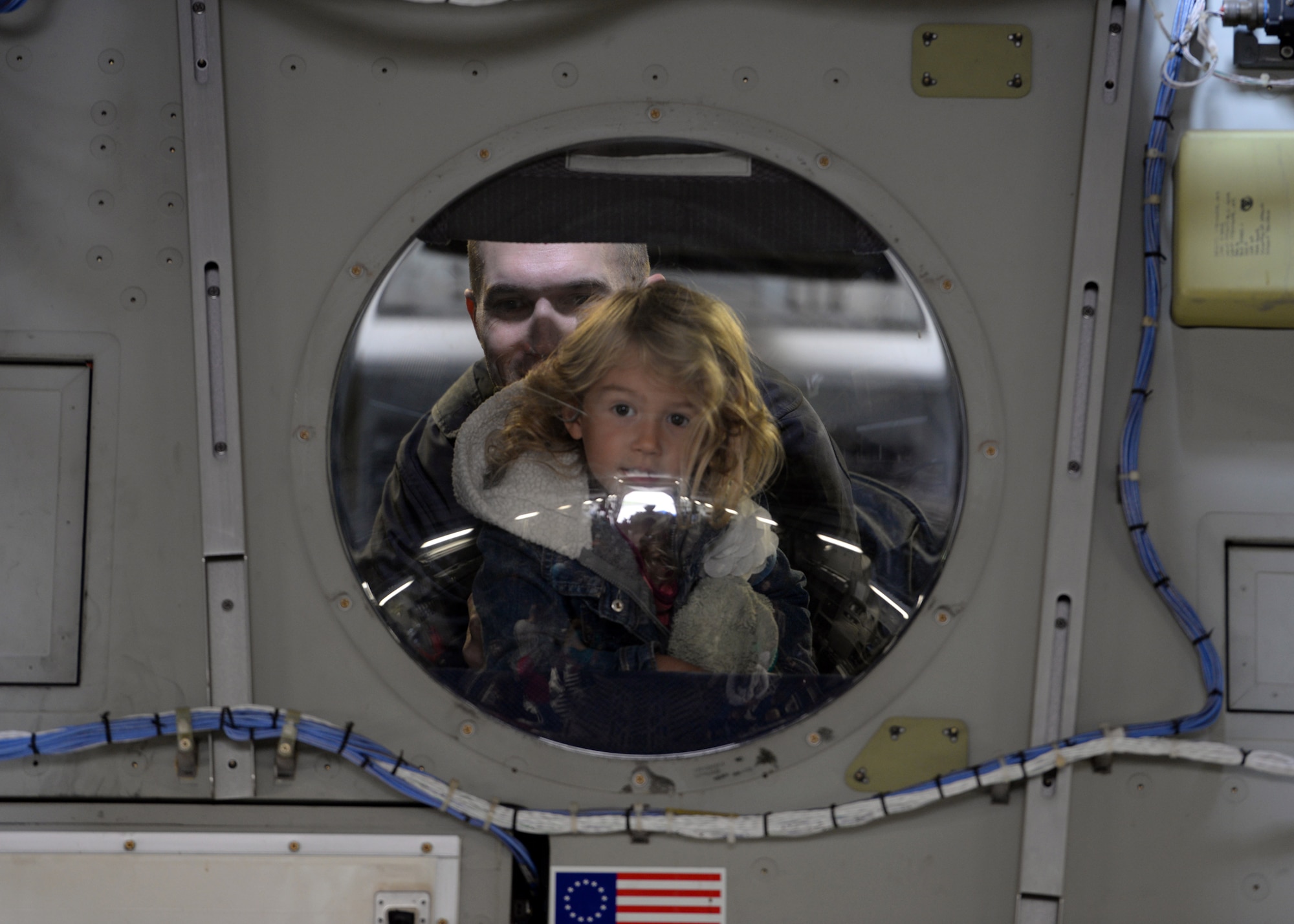 ALTUS AIR FORCE BASE, Okla. – U.S. Air Force Capt. Thomas Bockrath, and his daughter look out a window inside a C-17 Globemaster III cargo aircraft from Altus AFB during the 2014 Wings of Freedom Open House Sept. 13, 2014. Altus AFB is the training base for all U.S. Air Force C-17 pilots and loadmasters, as well as crew members for the KC-135 Stratotanker refueling aircraft. There were multiple static display aircraft lined across the flightline for spectators to observe inside and out while waiting for the aerial demonstrations to begin. (U.S. Air Force photo by Senior Airman Franklin R. Ramos/Released)
