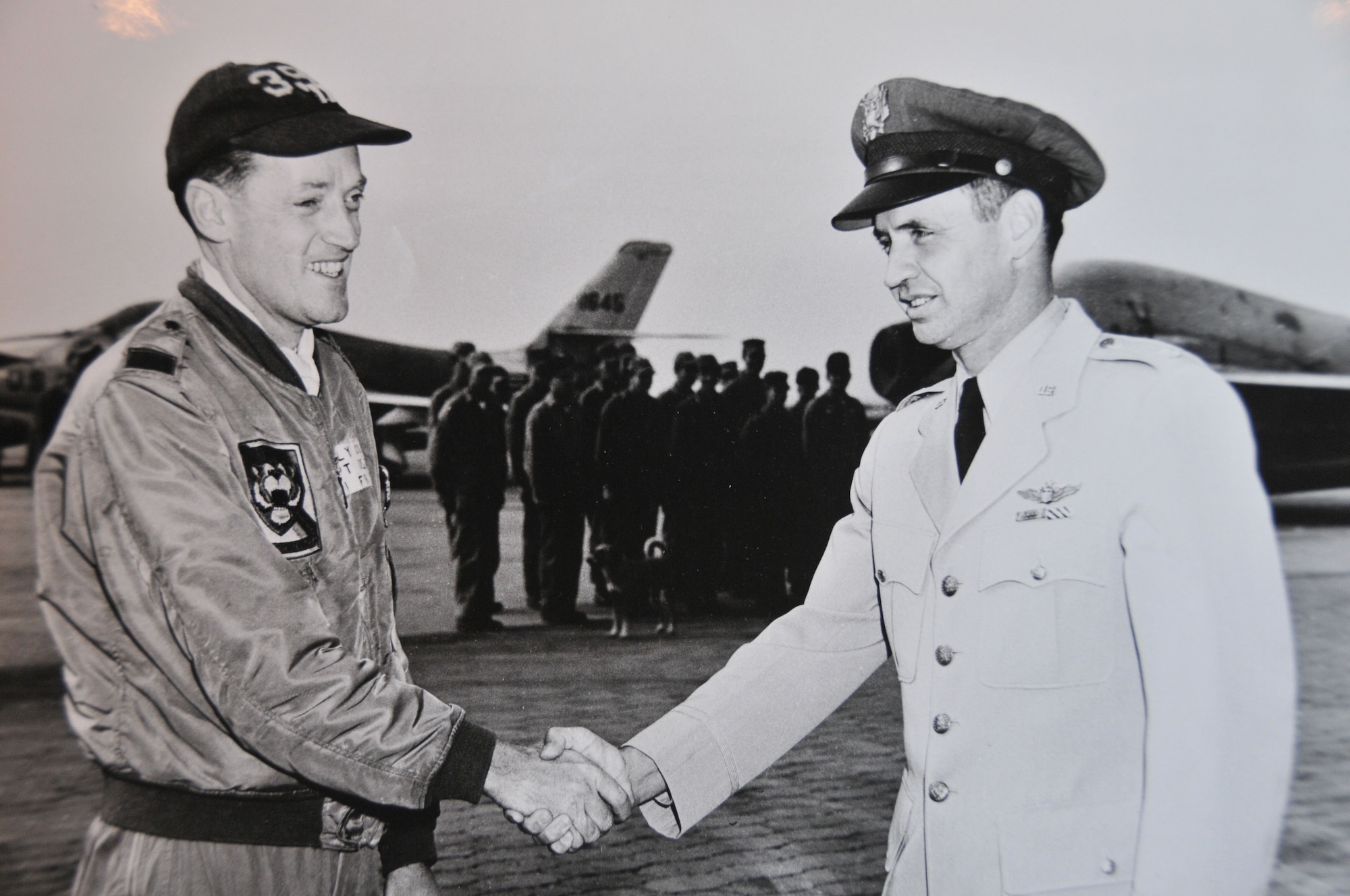 Air Force Capt. Kelly Cook (left), a pilot who flew early generation fighter bombers, shakes the hand of another officer circa 1950s. Cook, the father of 512th Airlift Wing Commander Col. Raymond A. Kozak’s wife Maureen, was a member of the Iowa Air National Guard when he was called to active federal service in support of the Korean War. Cook was later declared missing in action in 1967 after his F-4C was shot down over North Vietnam. (Submitted photo)