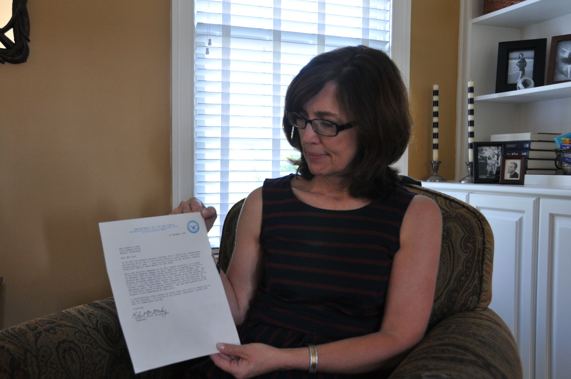 Maureen Kozak, the wife of Col. Raymond A. Kozak, the 512th Airlift Wing commander at Dover Air Force Base, Del., holds the formal memorandum dated Nov. 11, 1967, which notified Maureen’s mother of the circumstances that led to the missing status of Lt. Col. Kelly Cook. Maureen’s father was initially listed as missing in action and later declared killed in action, body not recovered. (U.S. Air Force photo/Staff Sgt. Mercedes Crossland)