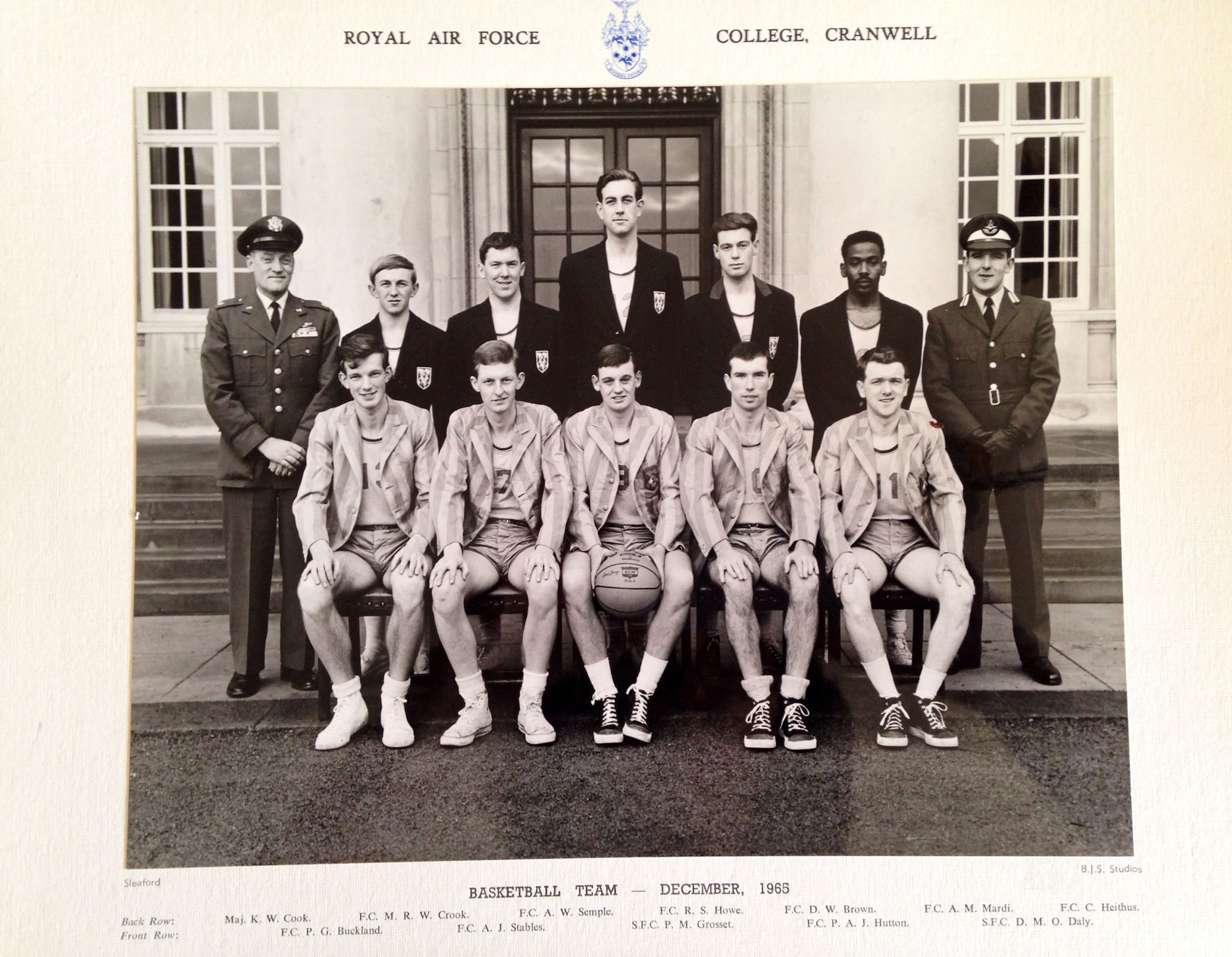 Air Force Maj. Kelly Cook (left) stands with the basketball team from Cranwell Royal Air Force College, United Kingdom, in 1965. Cook was assigned there as an English professor from 1963 to 1965. Two years later, Cook was declared missing in action in Vietnam. (Submitted photo)