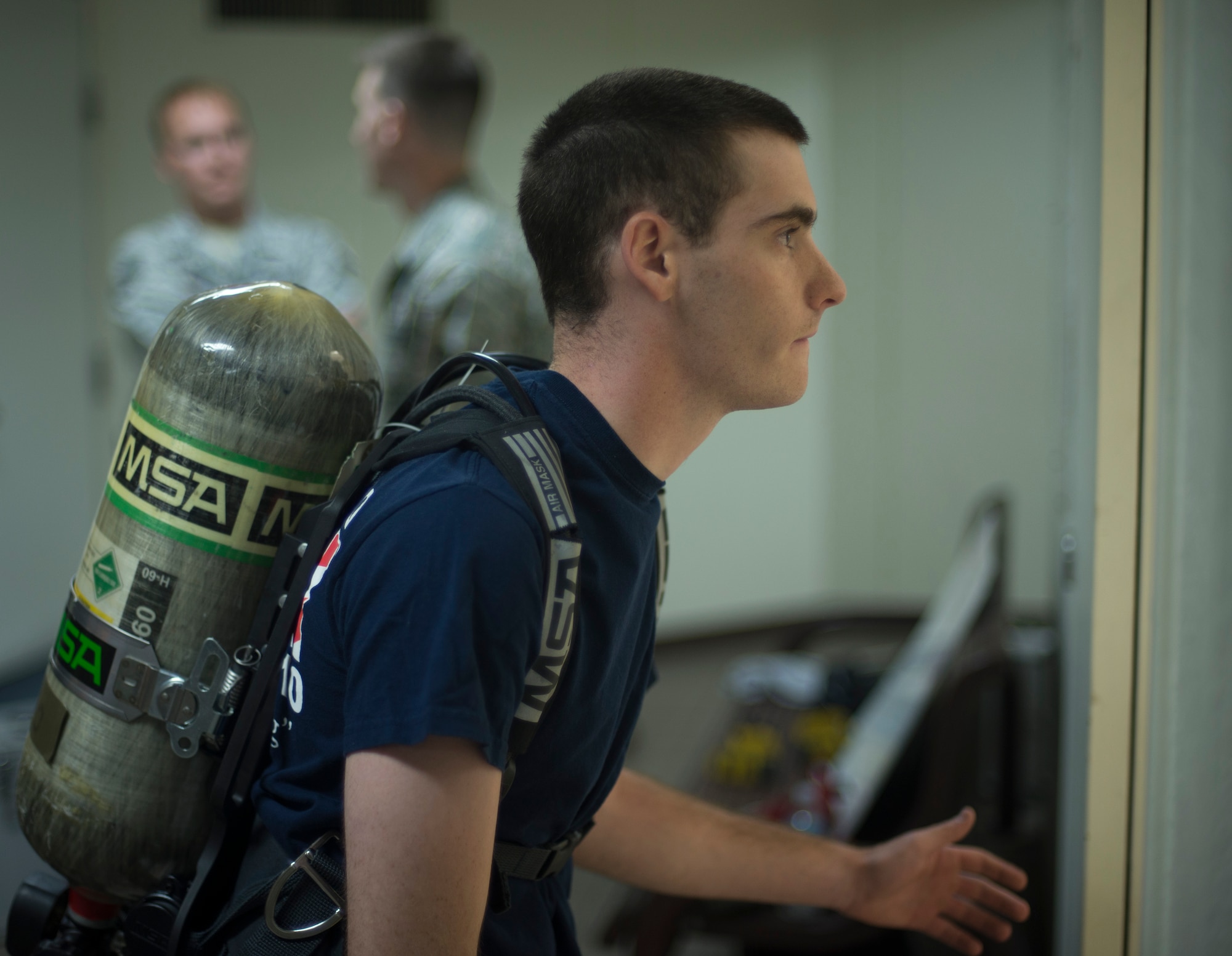 Airman Sean McMillan, 374th Civil Engineer Squadron structural apprentice, waits for his teammate to finish before starting his leg of the competition during the Sept. 11 Tower Run at Yokota Air Base, Japan, Sept. 11, 2014. Each member had to wear a 30-pound oxygen tank on their back as they competed. (U.S. Air Force photo by Senior Airman Michael Washburn/released)